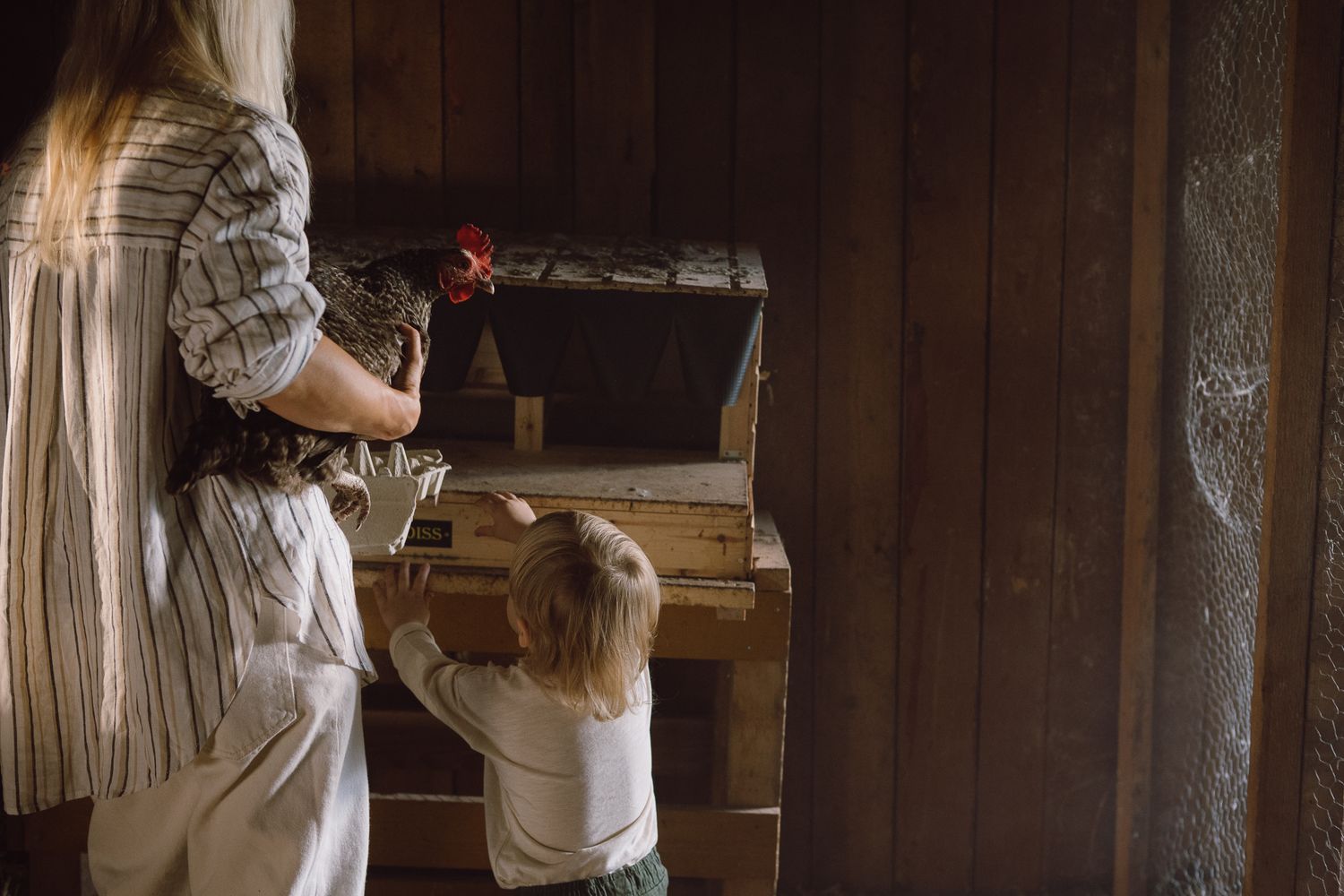Parent and child working together at a rustic wooden desk in a cozy interior setting.