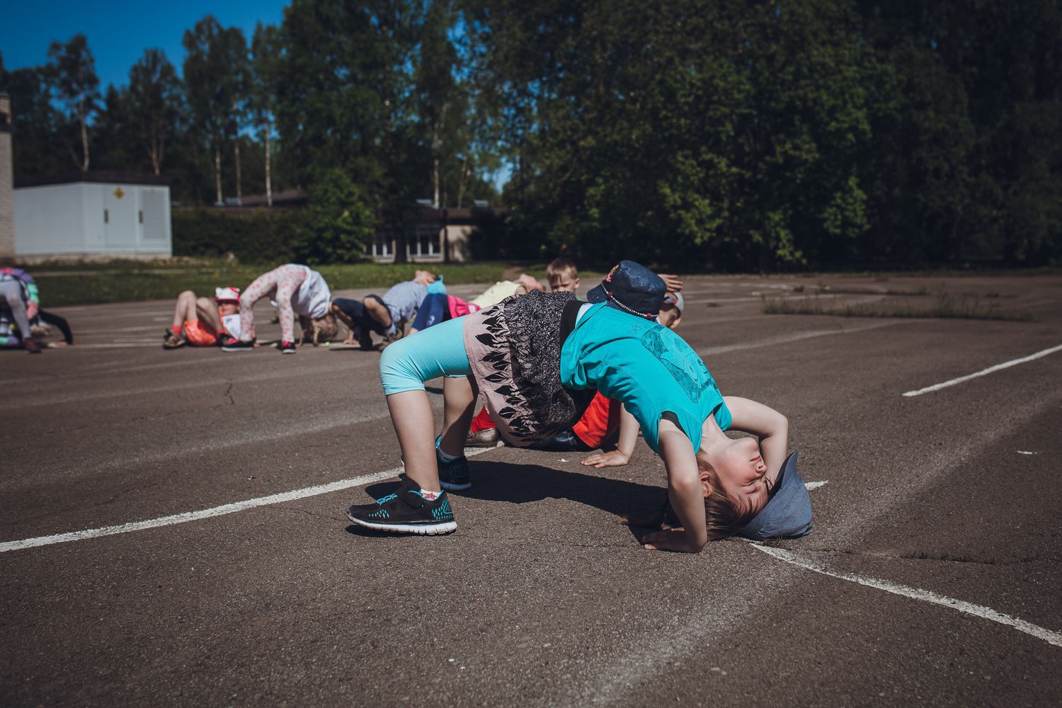 Students exercising on a paved outdoor court during physical activity.