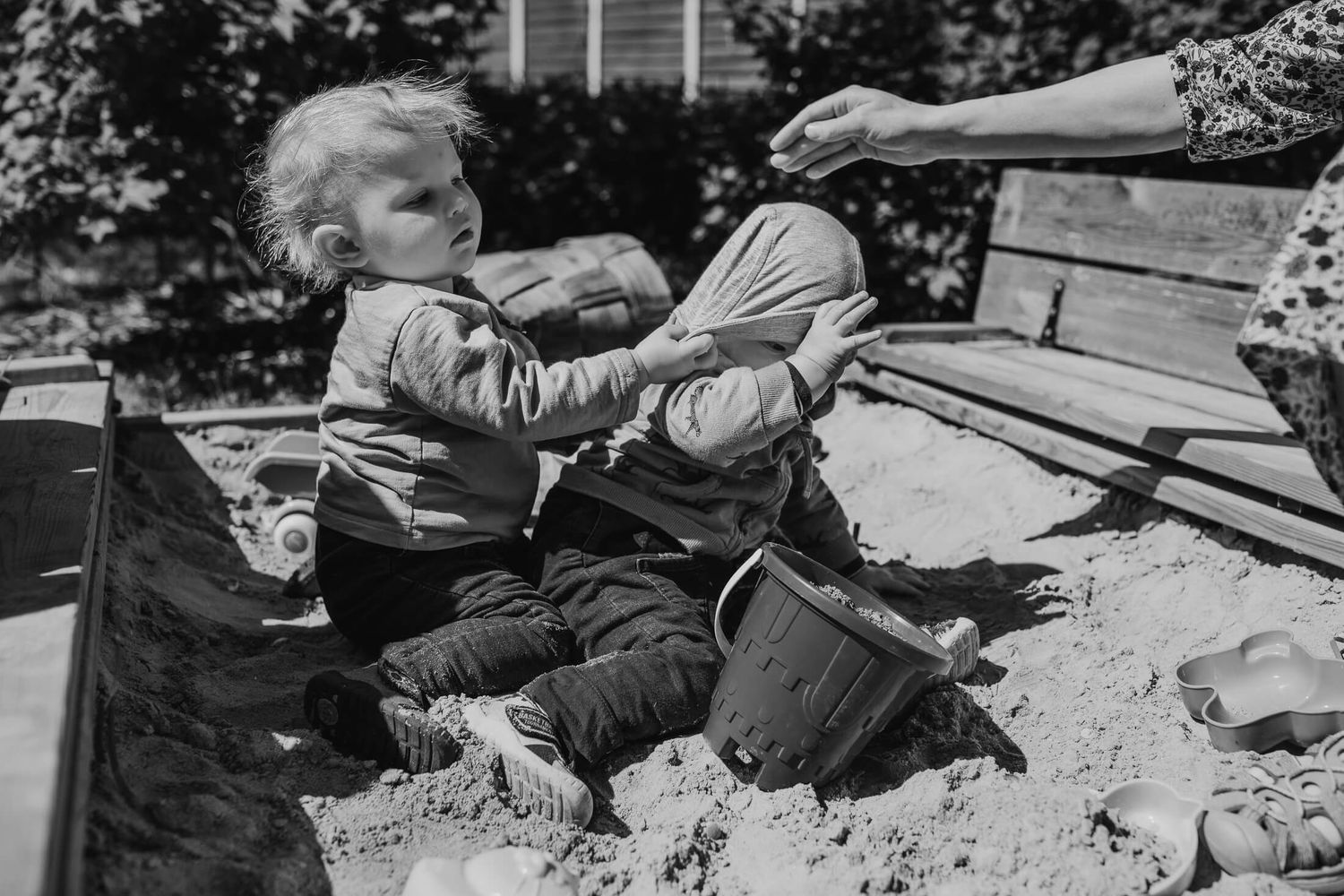 Black and white image of people lying on the ground in an artistic arrangement.