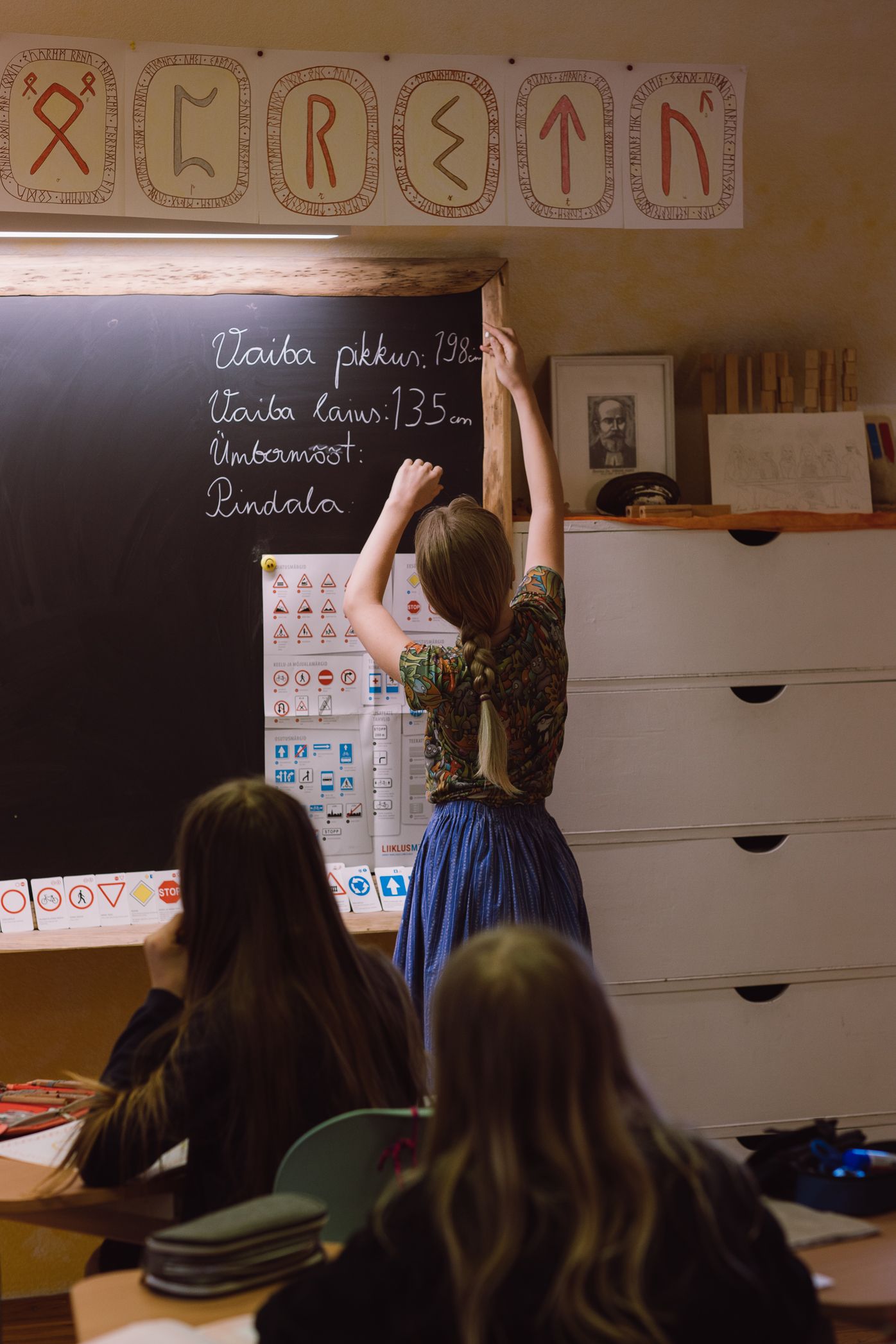 View of a classroom with educational symbols and writing displayed on blackboards.