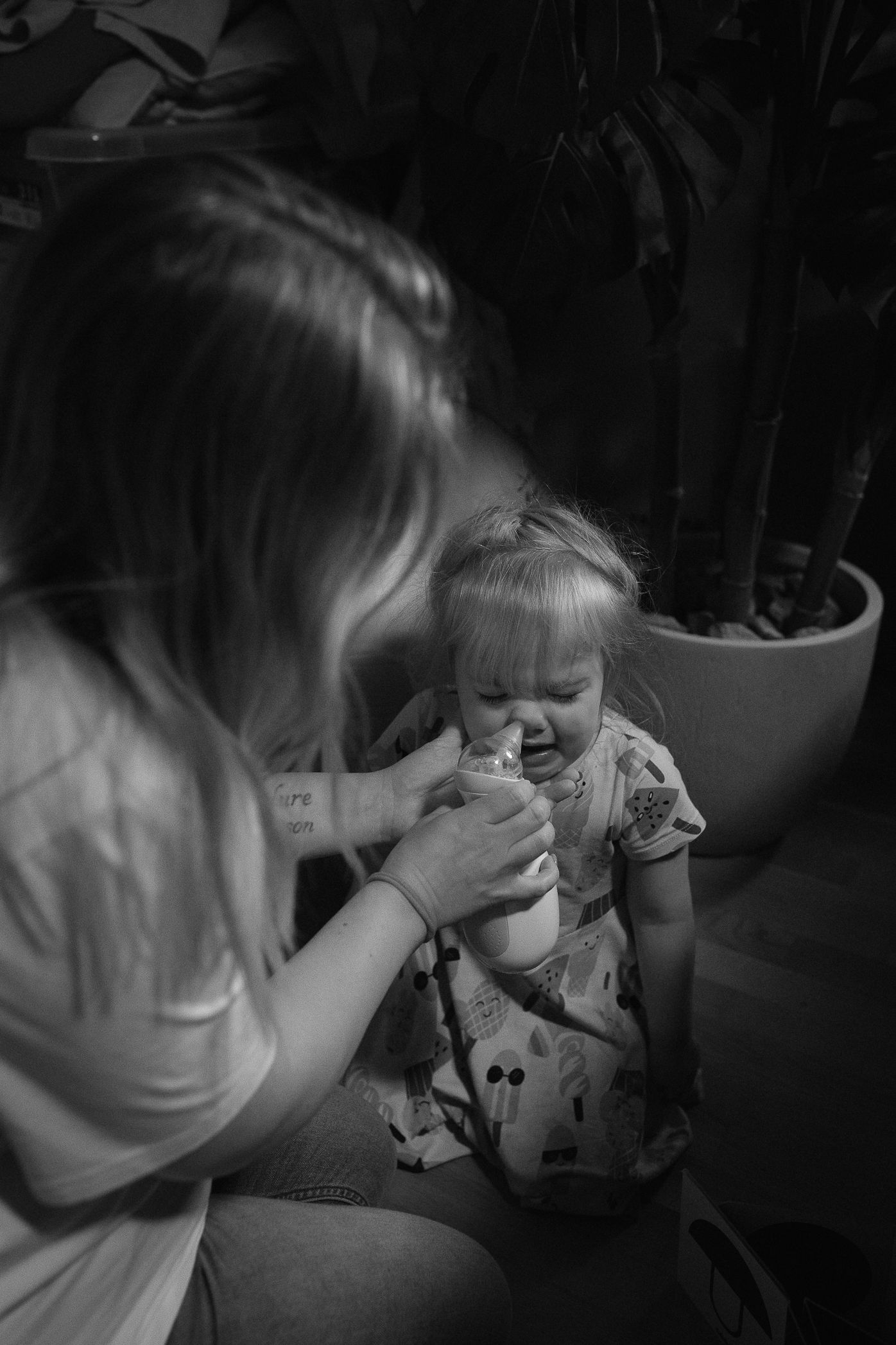 An intimate black and white moment of a child having their face wiped.