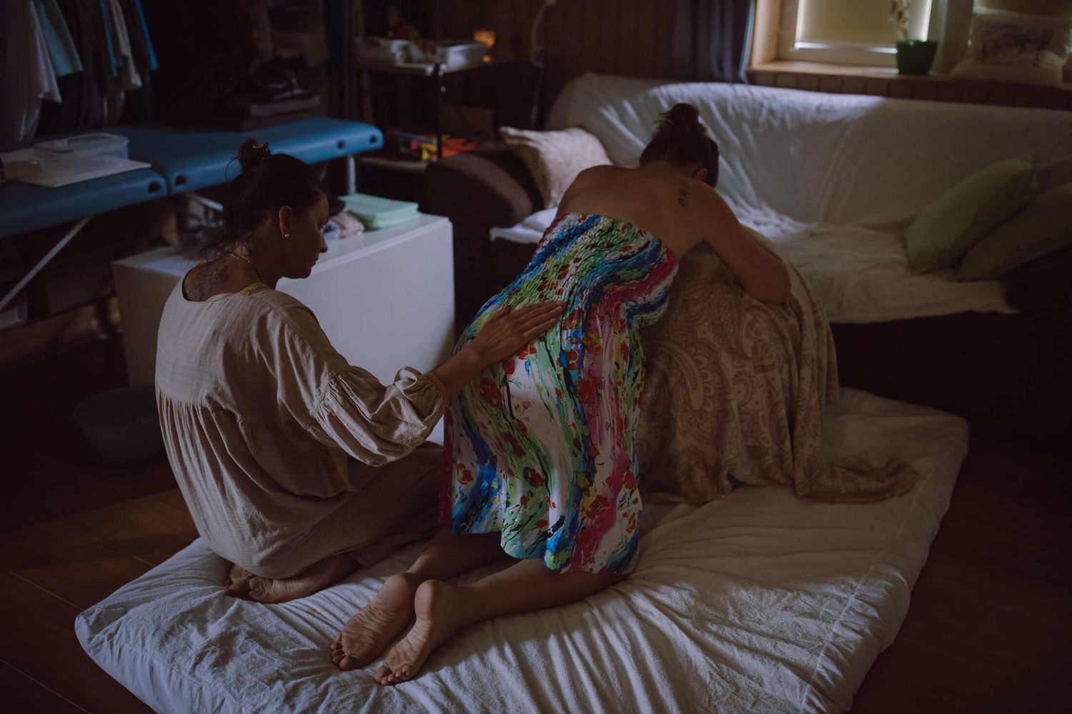 Patient lying on bed during medical treatment in dim lighting.