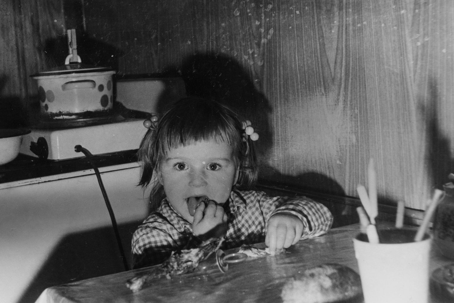 Vintage black and white photograph of a child at a table.