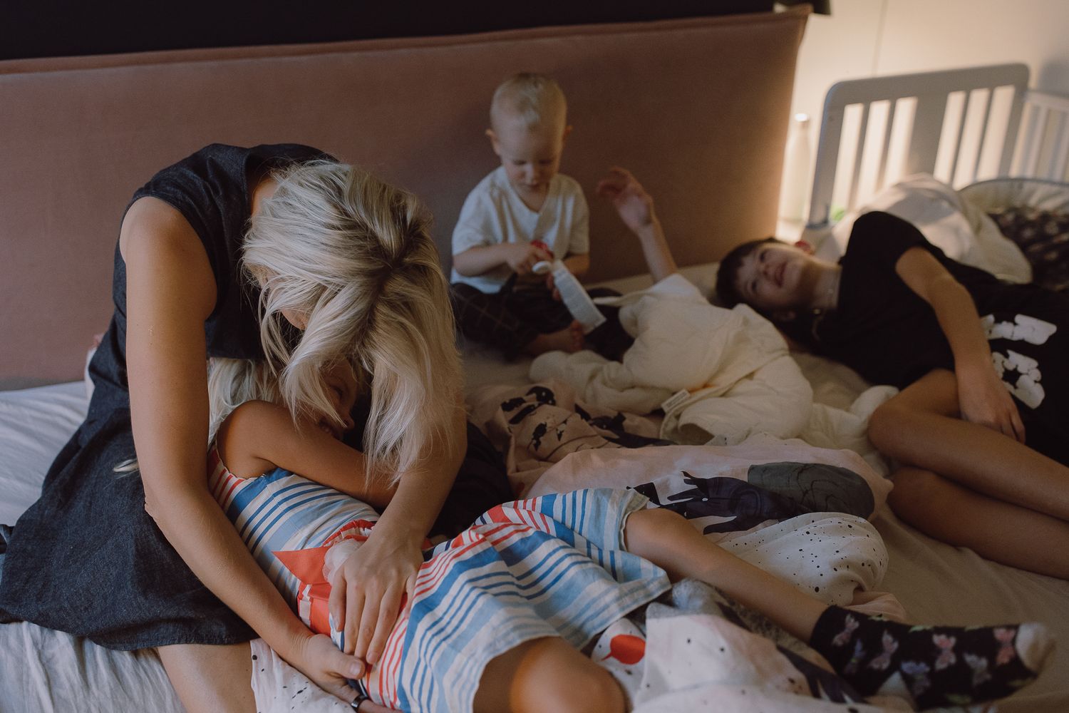 Family spending time together on bed during quiet moment at home.