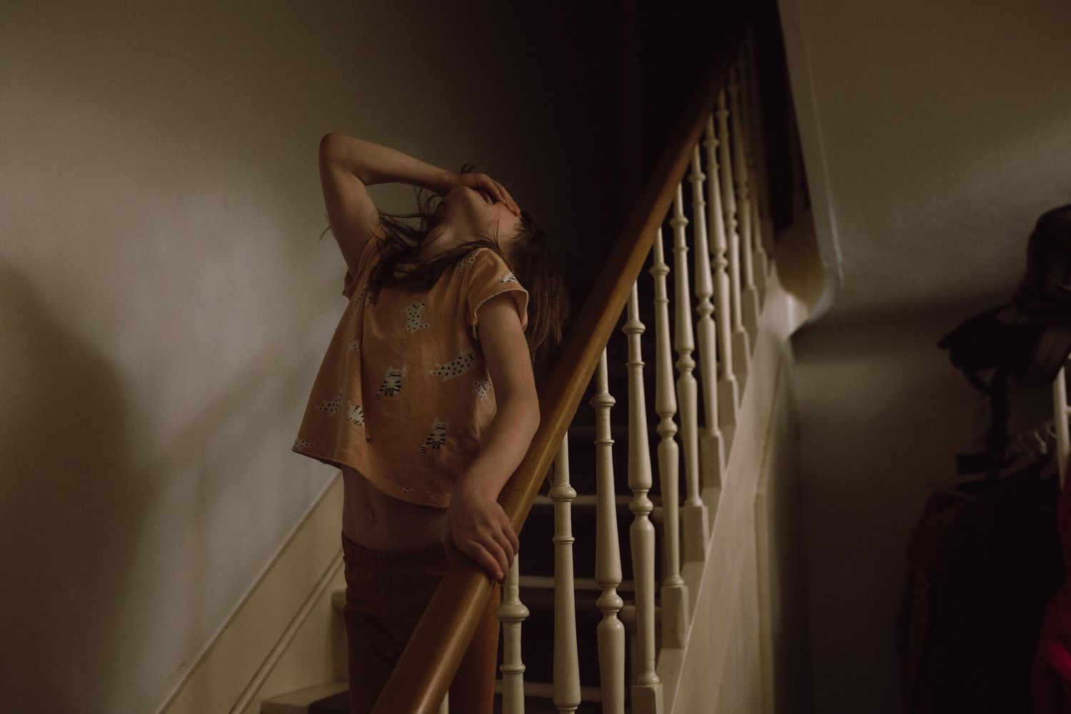 A dark and moody scene on a staircase with dramatic lighting and shadows.