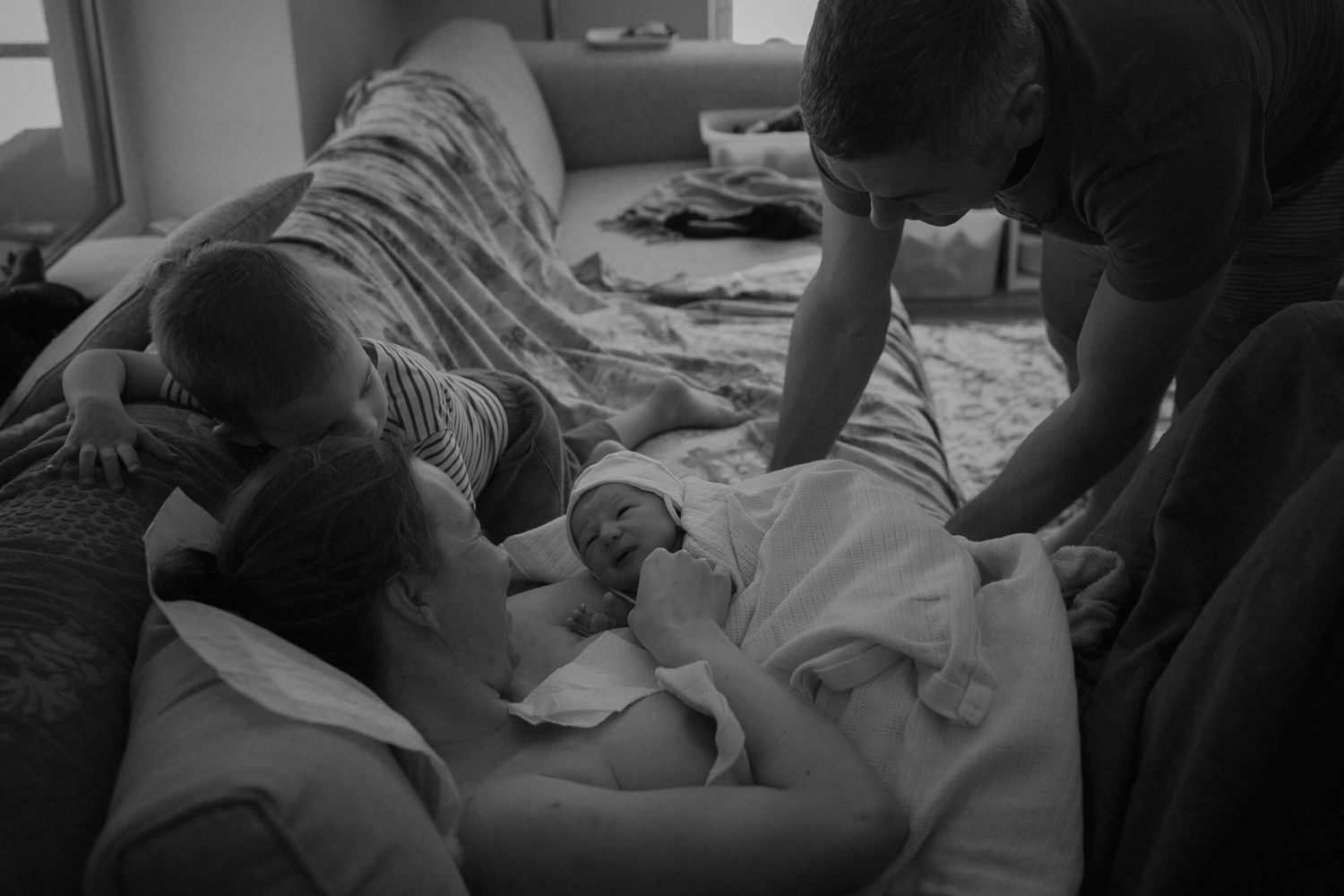 Caregivers attend to a birthing moment in a home setting.