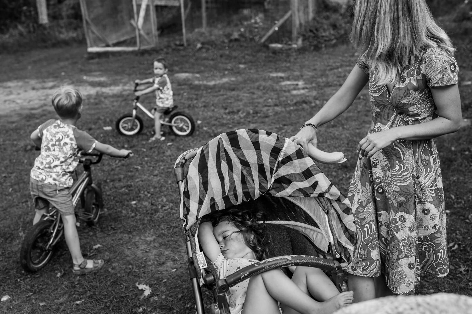Children playing outdoors with bicycles on a sunny summer day.