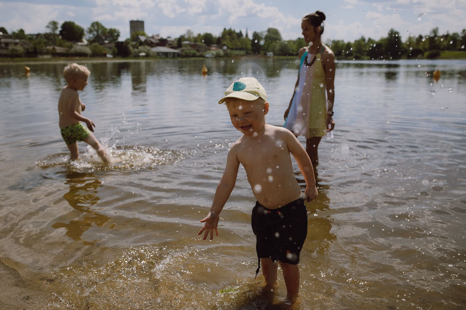 Children playing and splashing in a shallow lake on a sunny summer day.