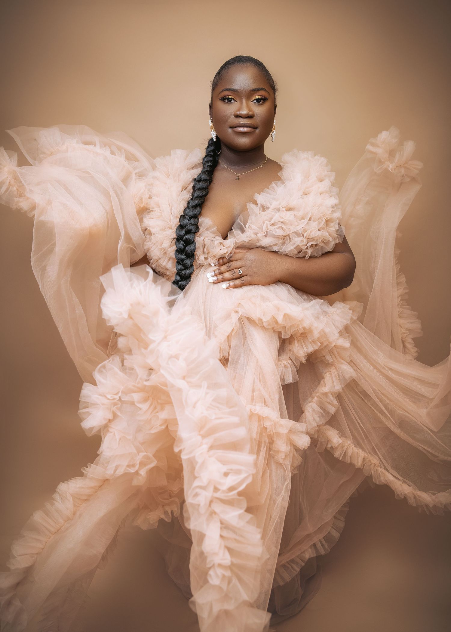 A figure in a flowing peach-colored tulle dress poses gracefully in a series of artistic portrait photographs.