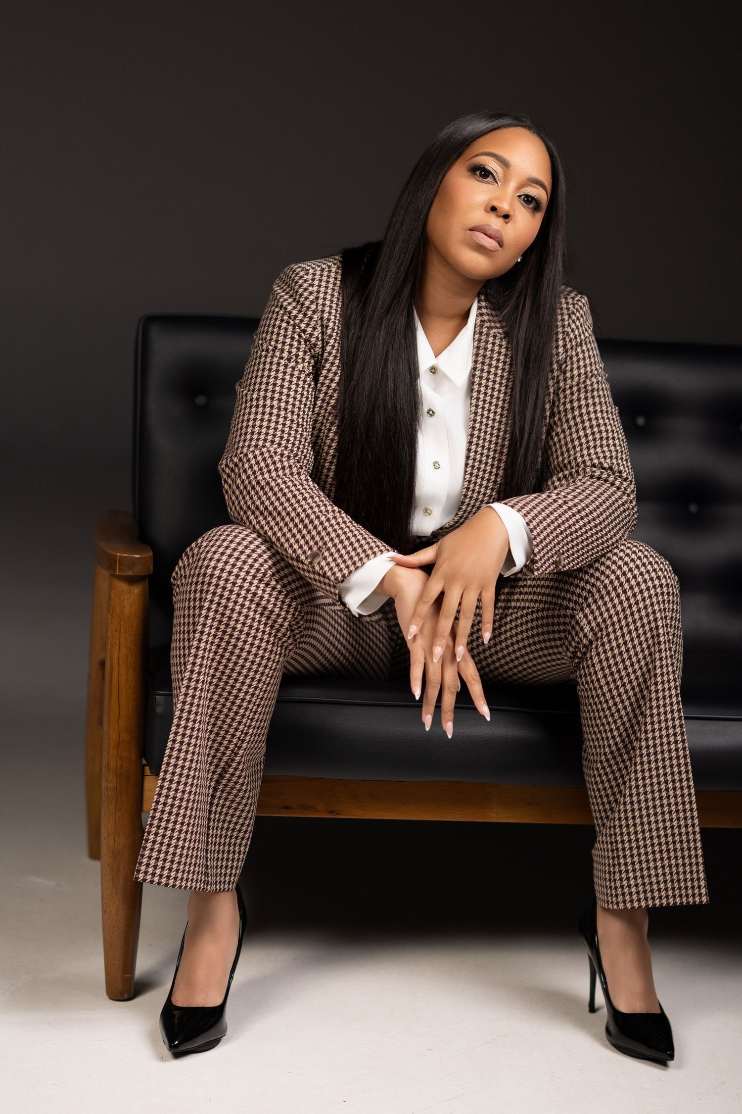 Professional fashion photography series showing a brown checkered pantsuit in various poses on dark background.