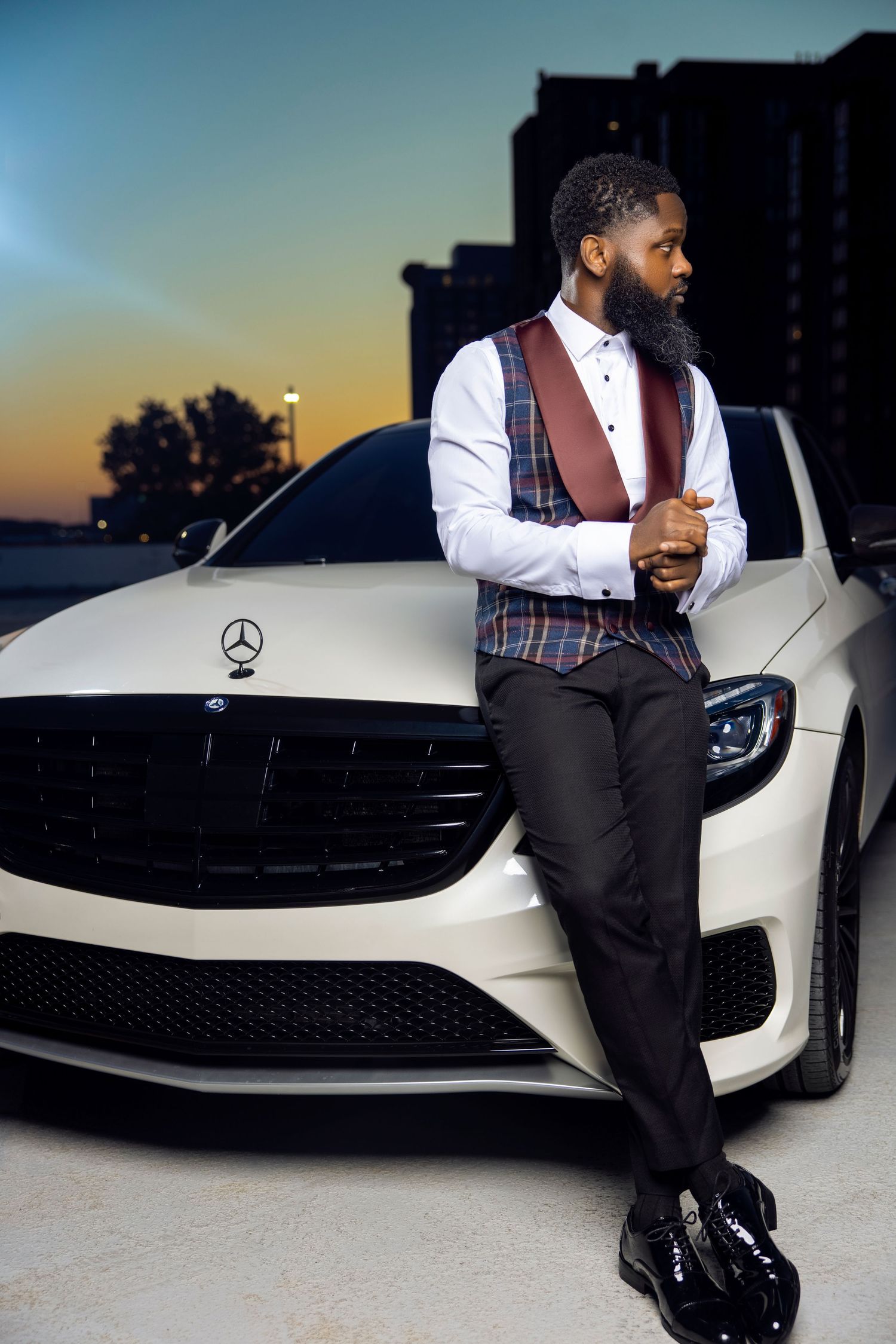 Stylish portrait session with white Mercedes-Benz on rooftop during sunset.