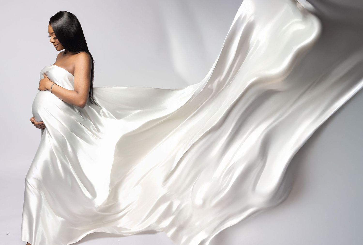 White silk fabric flowing and billowing elegantly against a light background creating soft, graceful curves.