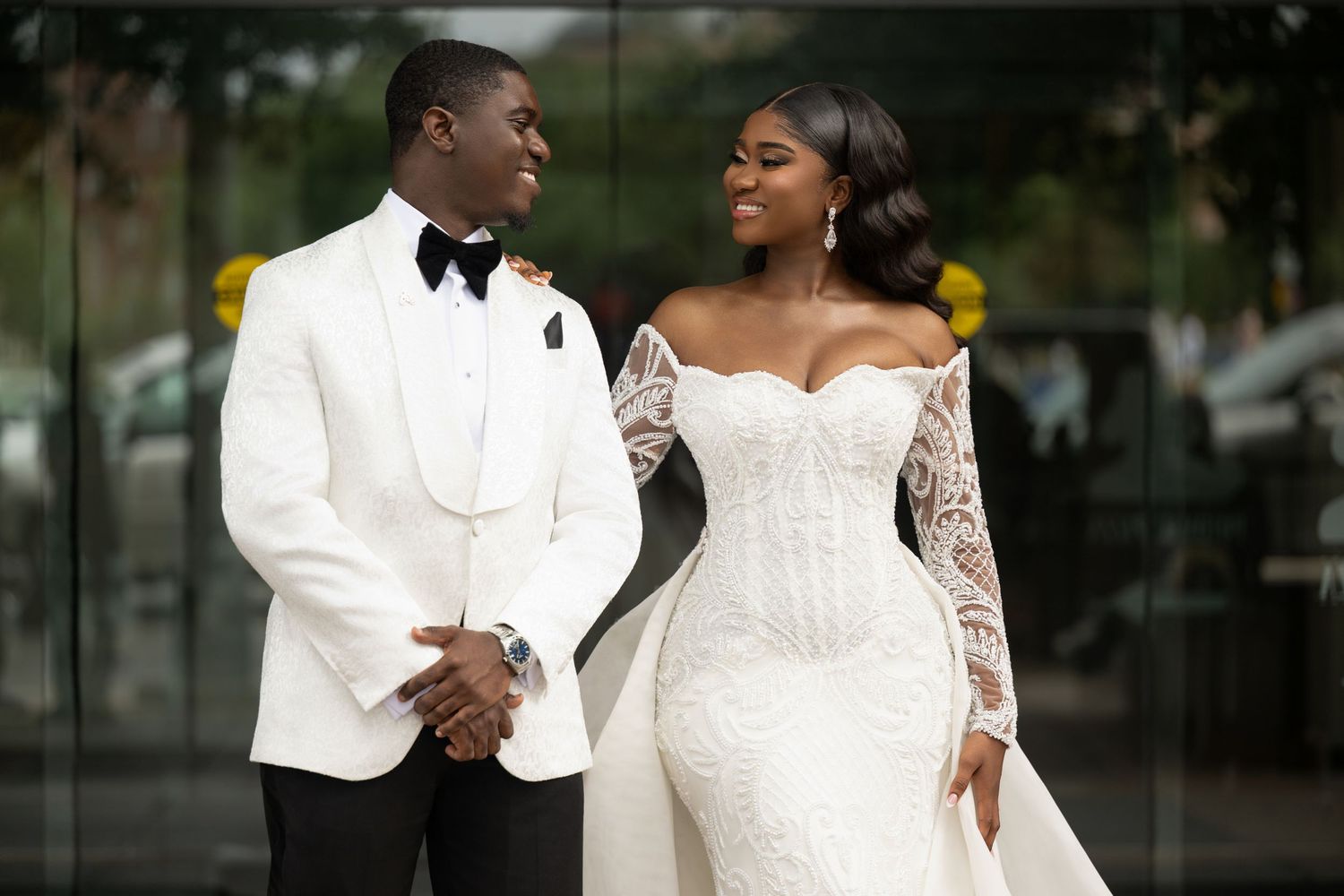 Romantic wedding portrait of couple in white tuxedo and lace gown.