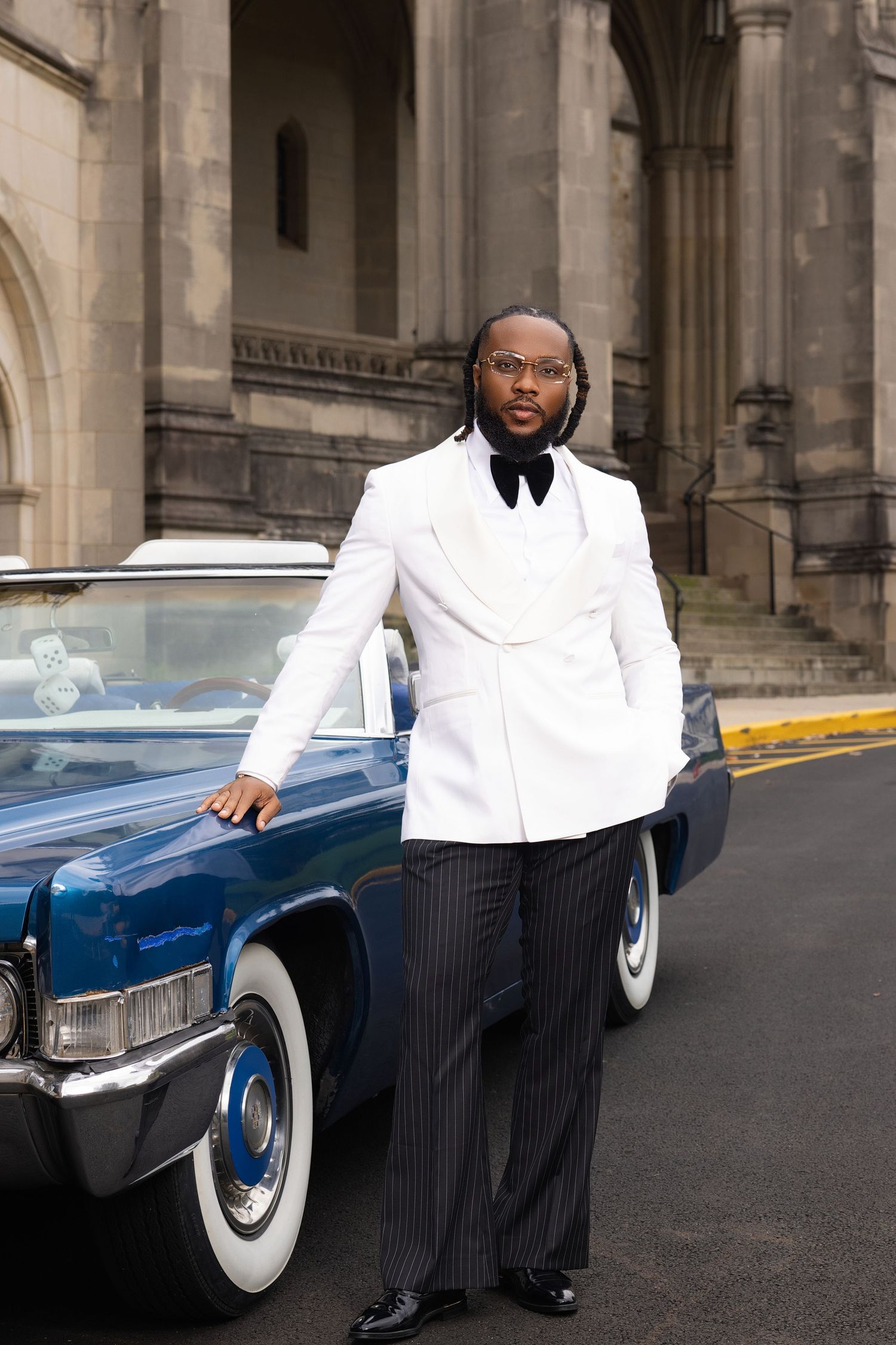 Classic photo shoot with vintage blue car featuring white tuxedo and pinstripe pants.
