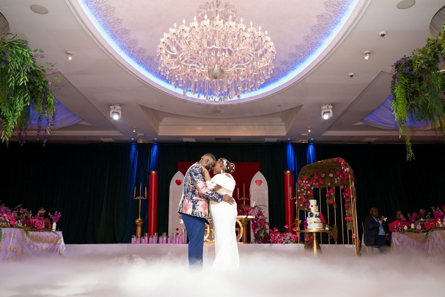A grand ballroom decorated with crystal chandeliers and elegant lighting for a formal celebration.