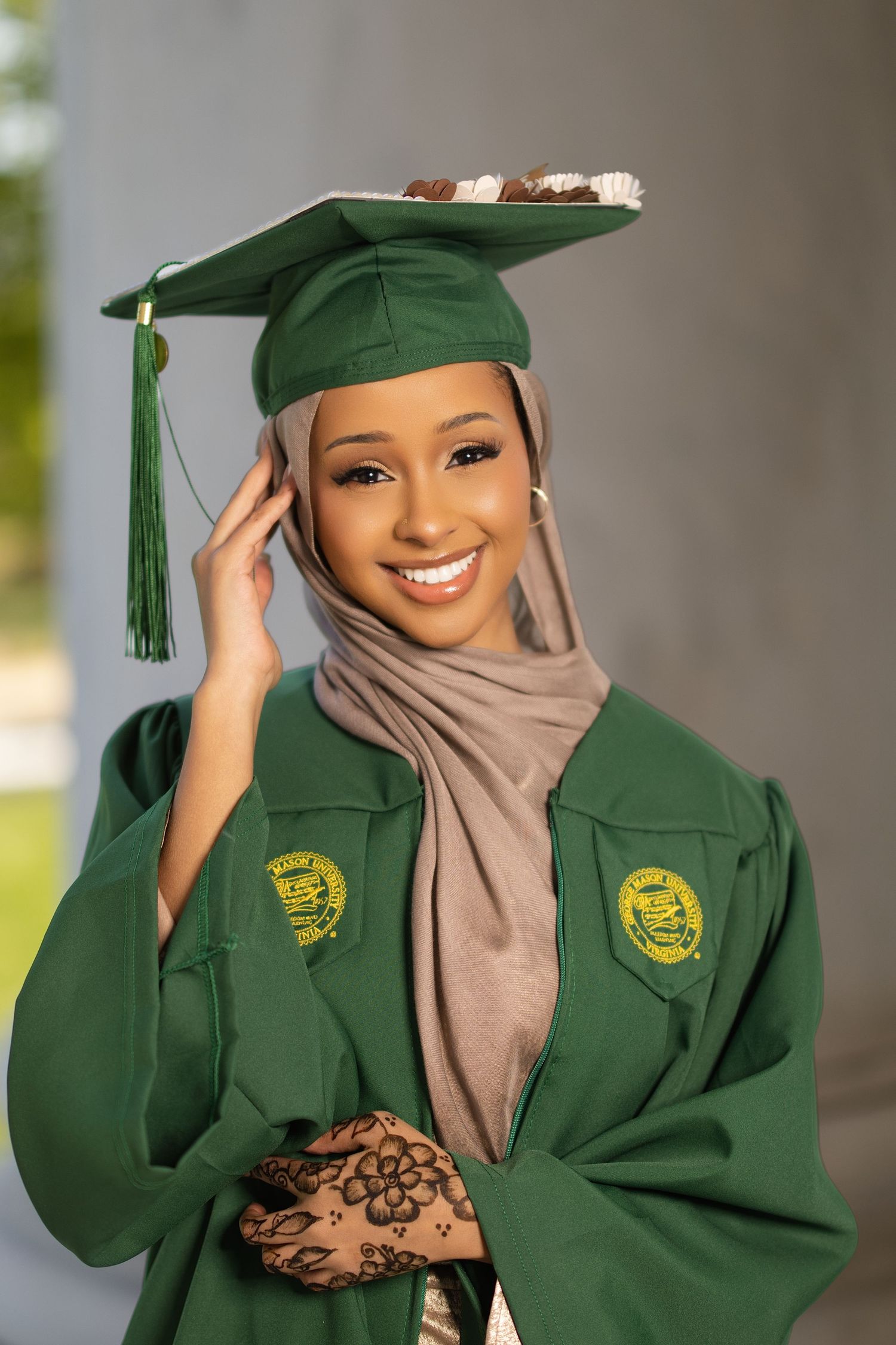 Graduate in green cap and gown with beige hijab poses for a series of celebratory graduation photos.