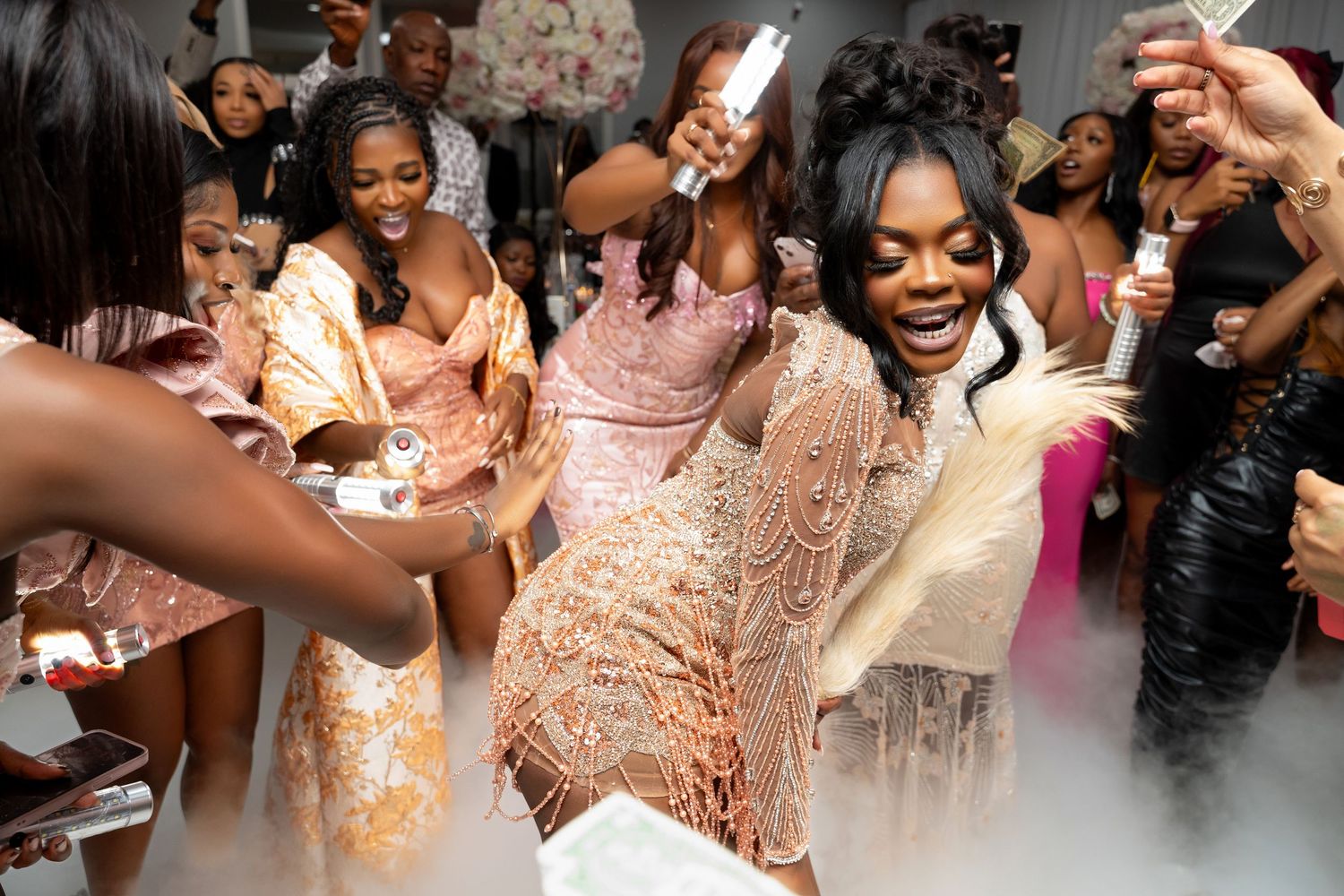 A group of wedding guests dance and celebrate joyfully at a reception party in formal attire.