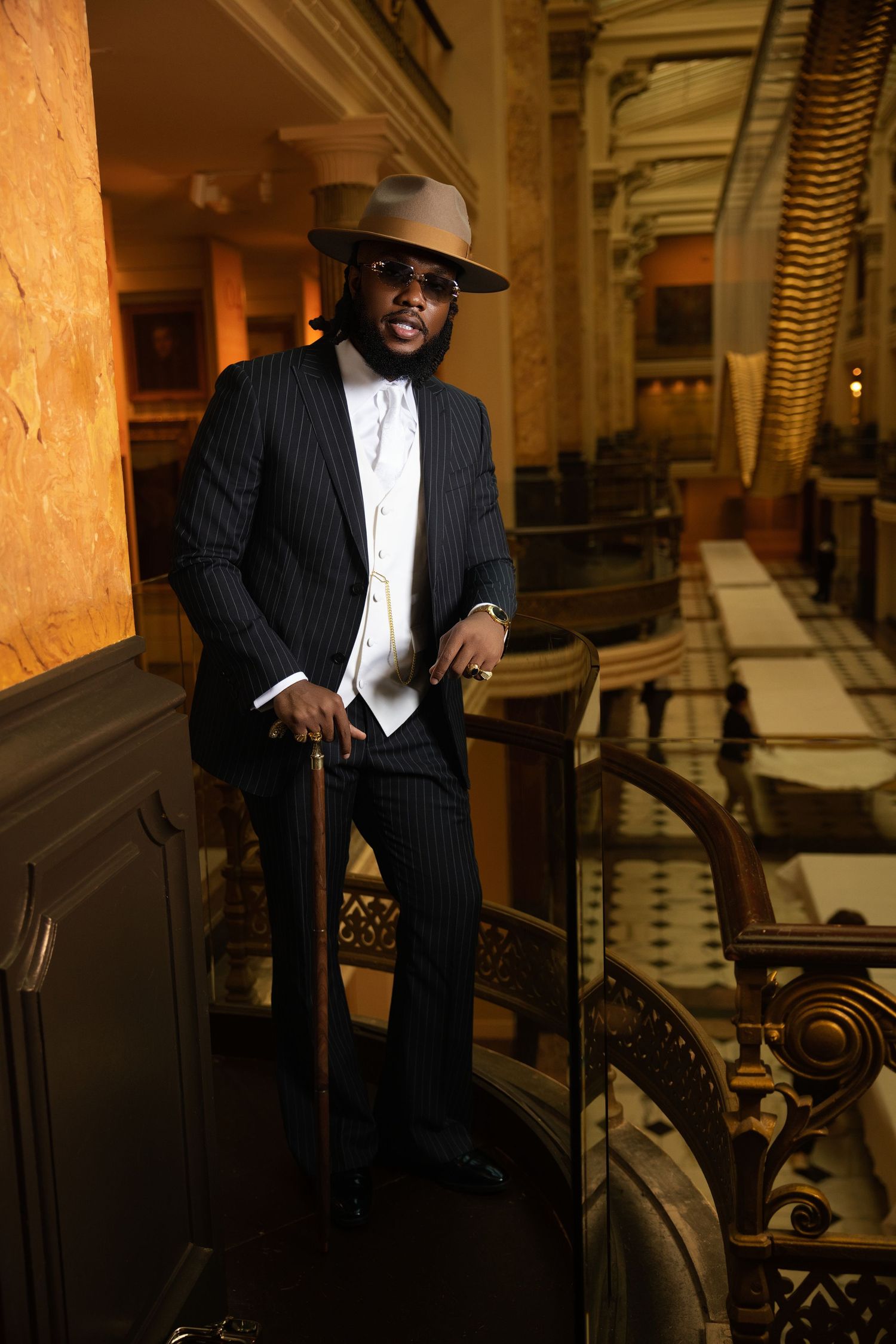 Sophisticated indoor portrait session with dramatic lighting and architectural backdrop.