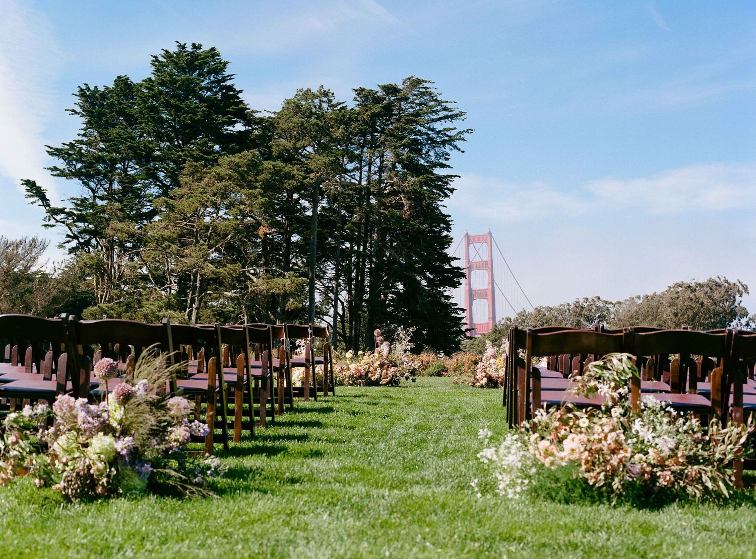Wedding ceremony on lawn in front of the Golden Gate Bridge.