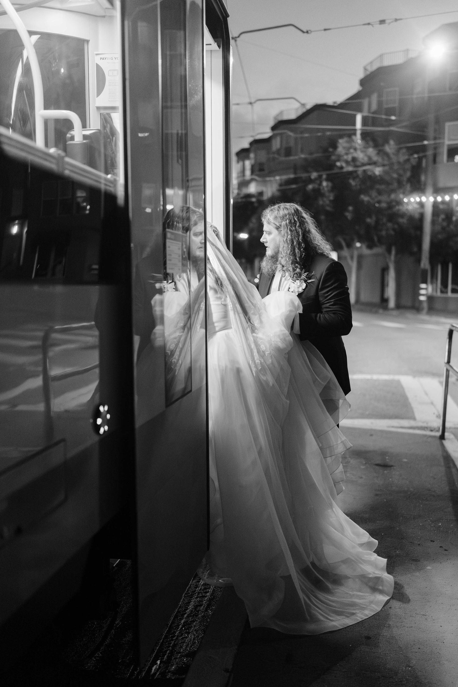 Black and white image of bride and groom getting into a Muni metro car.