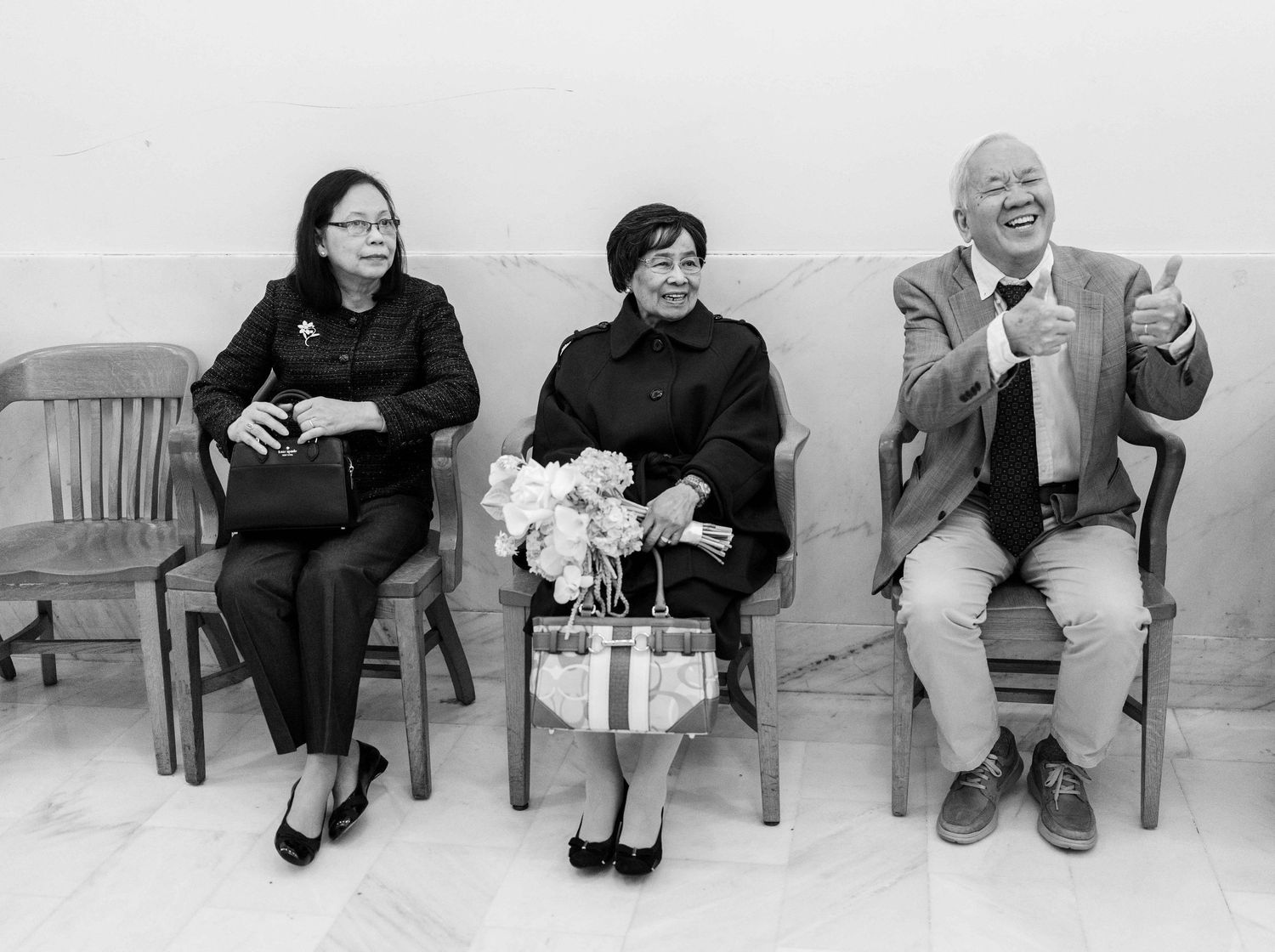 Grandparents giving thumbs up in hallway.