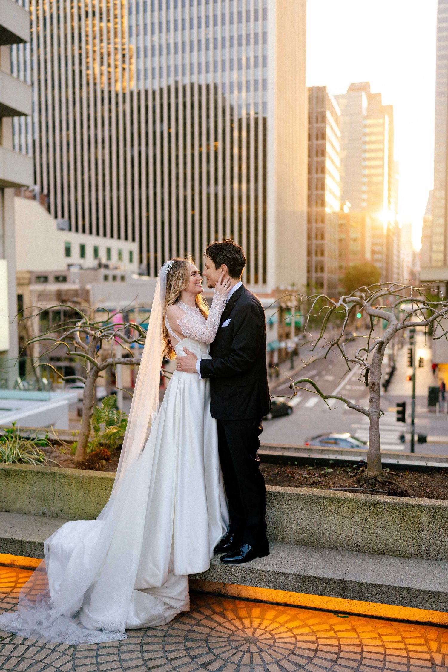 Golden hour wedding portrait against modern SF architecture with glowing orange pathway.