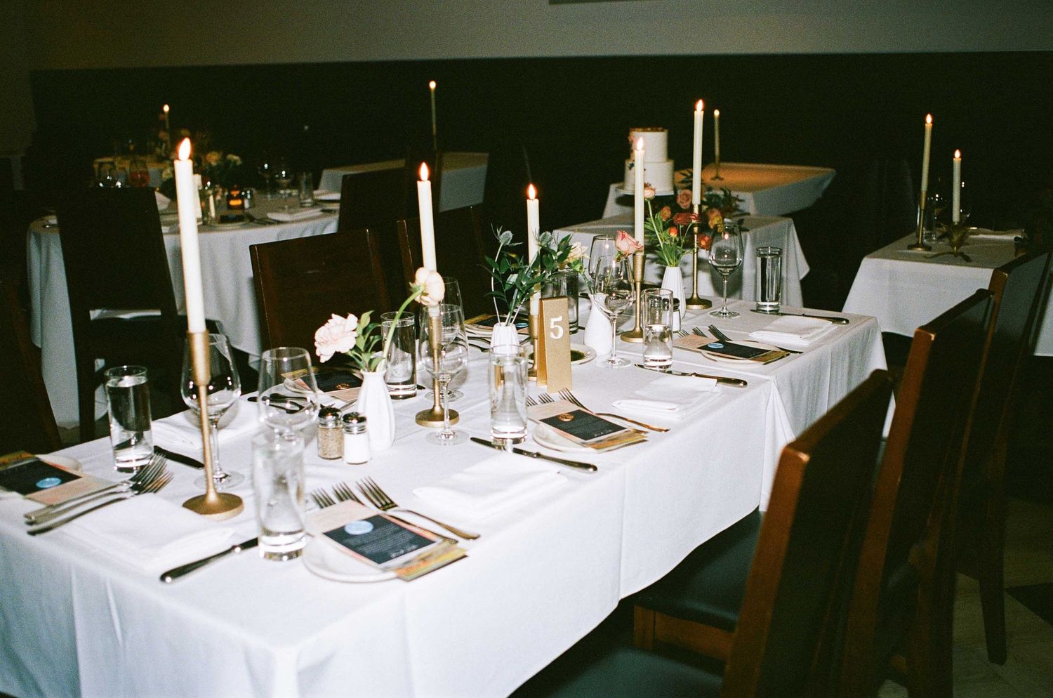 Formal table setting with white linens, candlesticks, and place settings for an elegant dinner party.