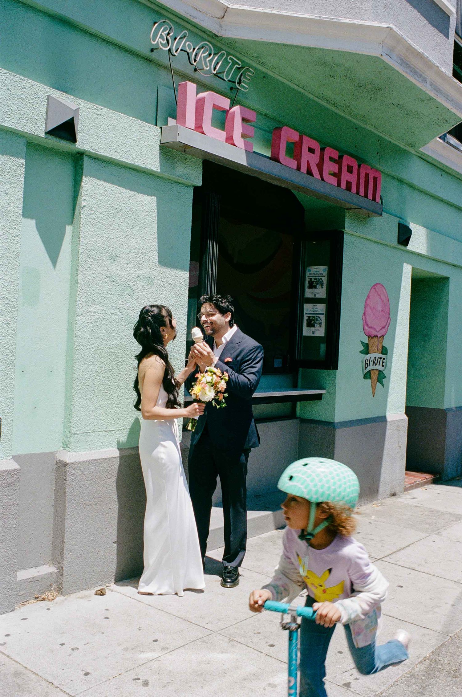 Bride and groom laugh together outside Bi-Rite Ice Cream shop in San Francisco.