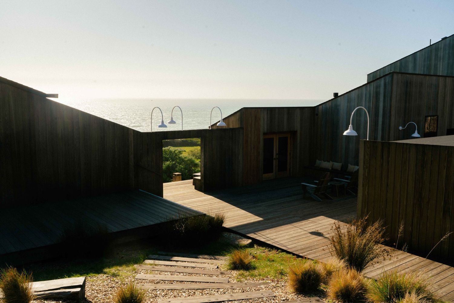 Mid-century modern wooden portal overlooking the Pacific Ocean at sunset.