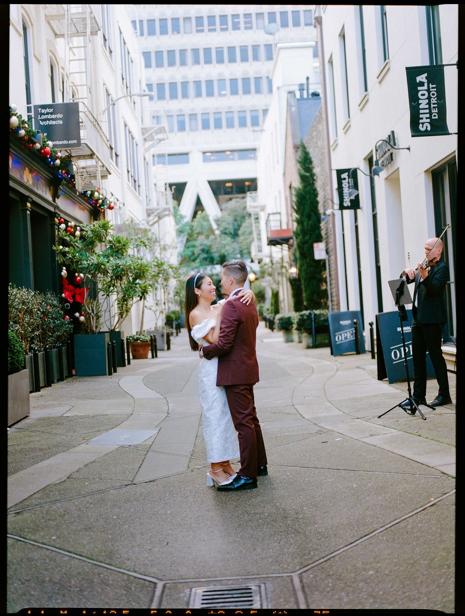 A romantic moment captured on a charming SF Financial District street with decorative lights and urban architecture.