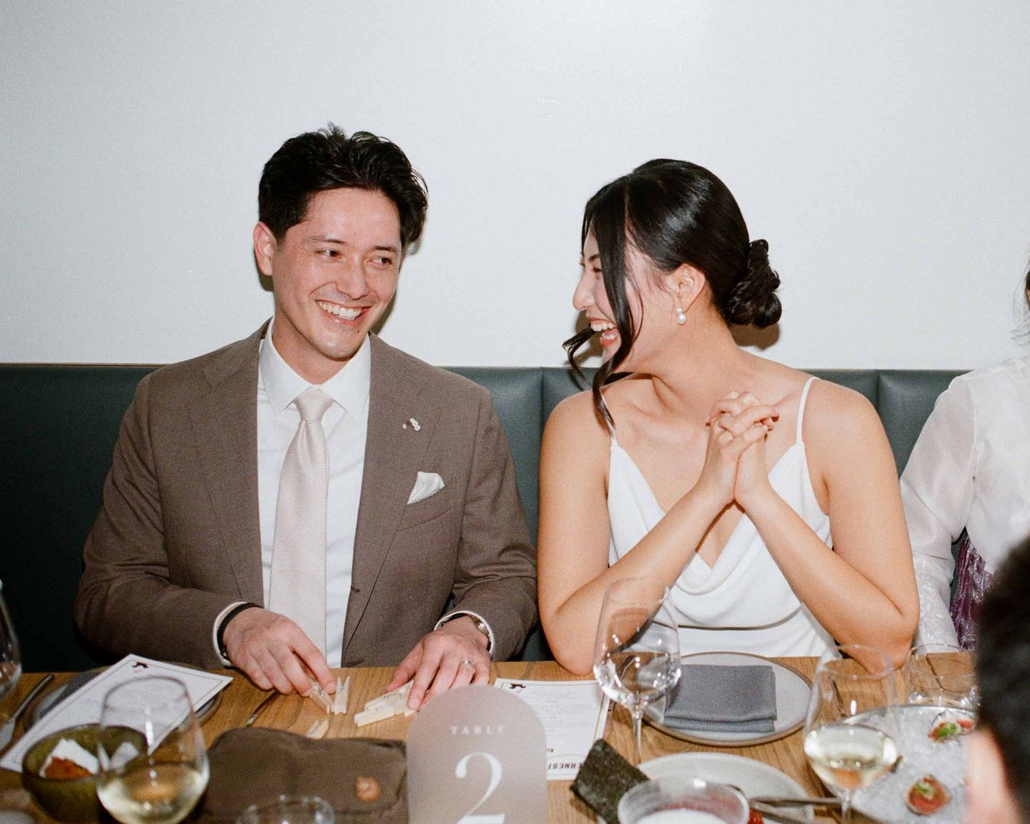Bride and groom laughing while looking at each other.