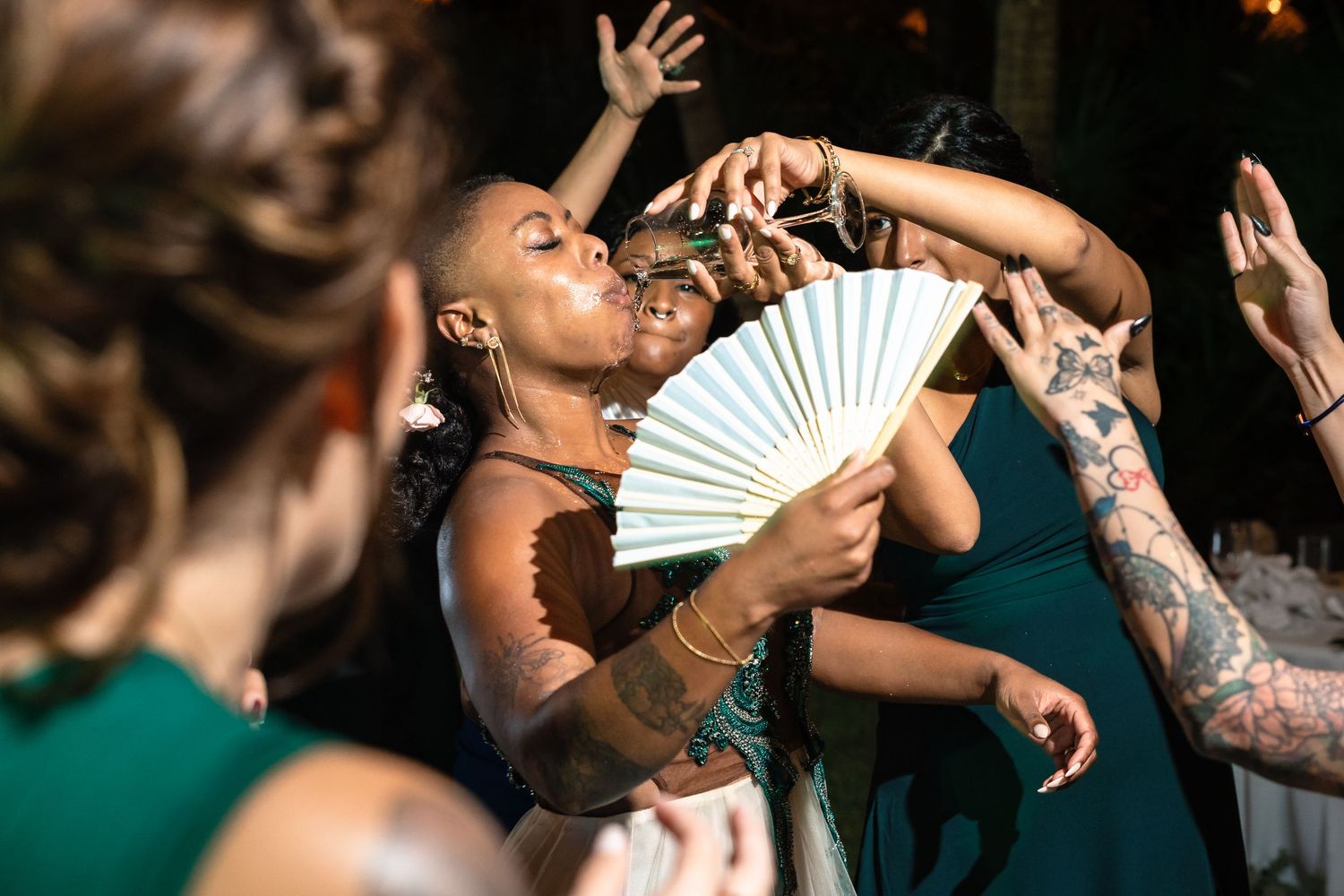 Invitada bailando con un abanico durante la recepción.