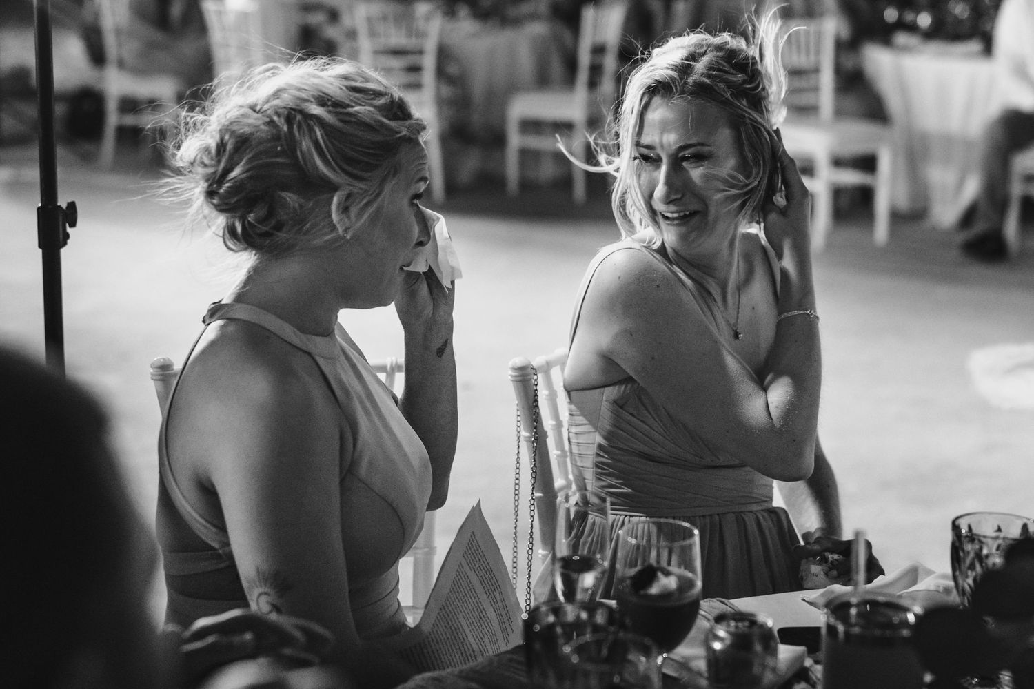 Novia conversando y riendo con una invitada durante la recepción.