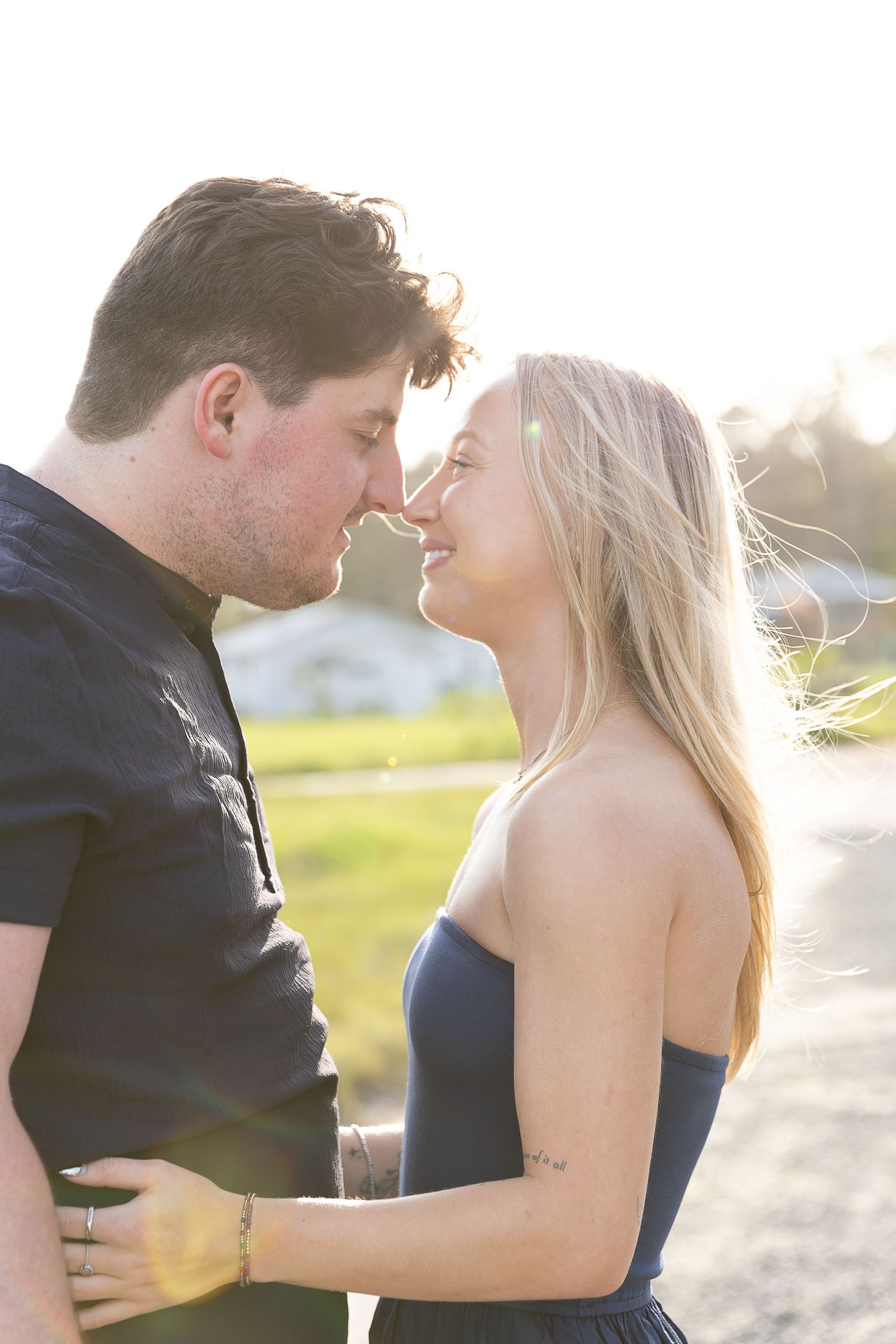 Couple sharing romantic moment nose-to-nose in golden sunset backlight outdoors.