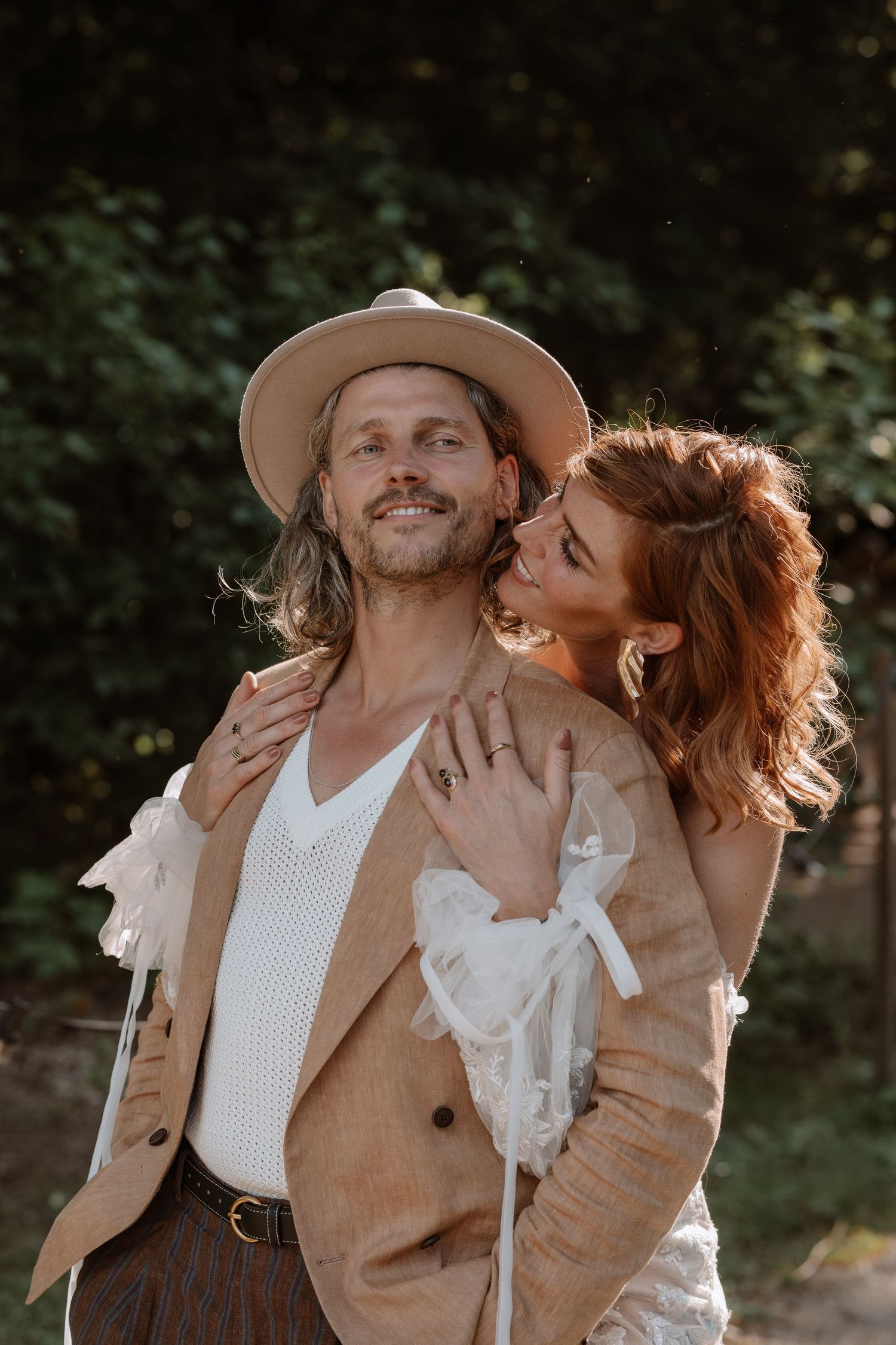 Romantic outdoor scene with couple in tan and white clothing.