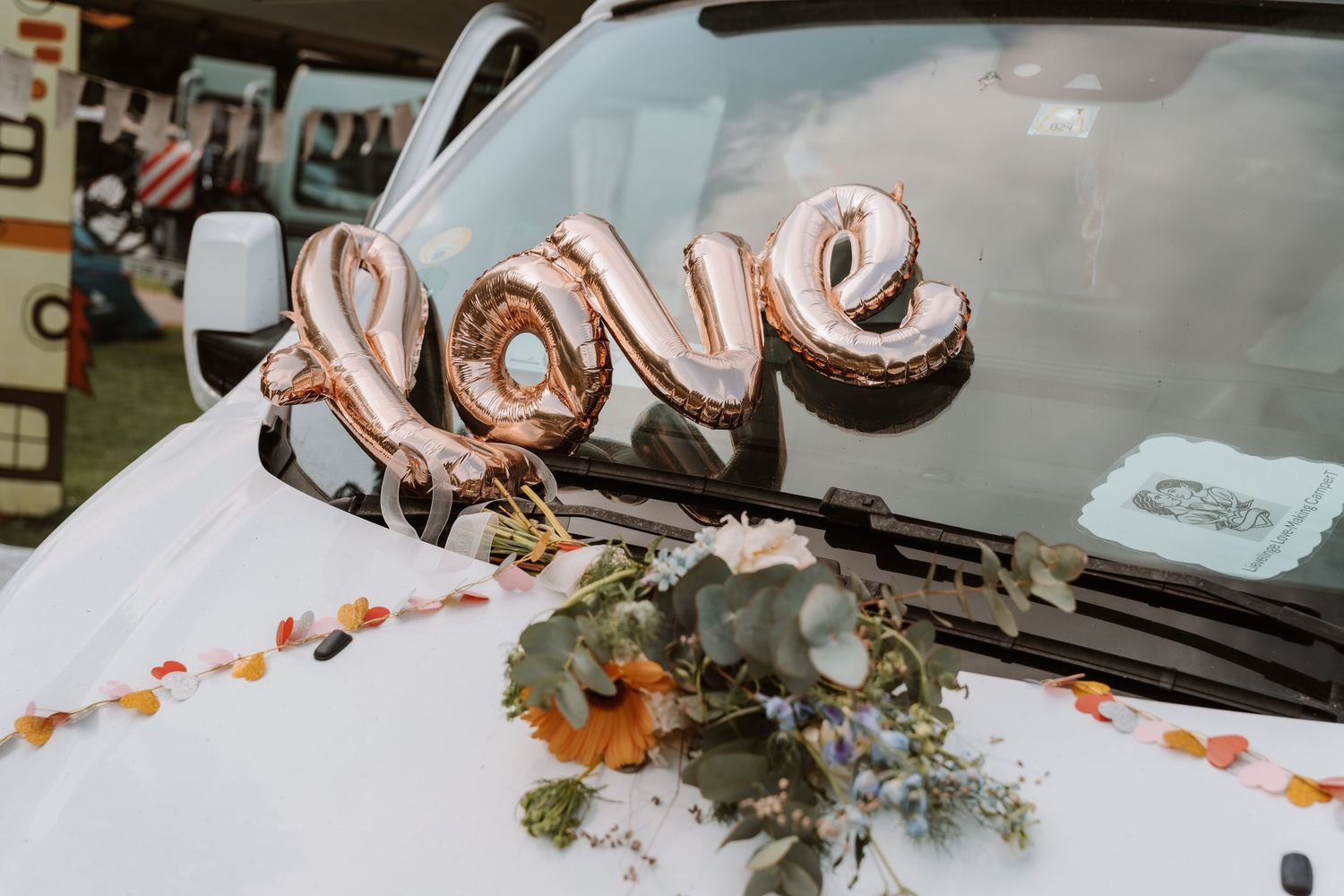 A decorated vintage car with 'Just Married' signage and floral arrangements.