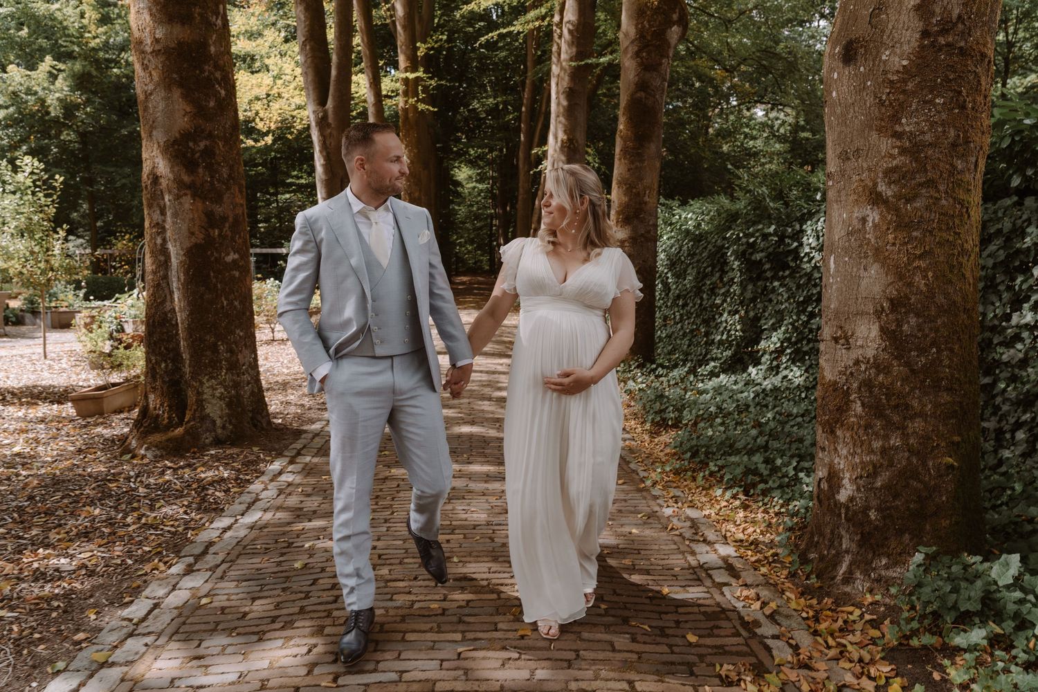 Couple walking together on wooden pathway through forest.