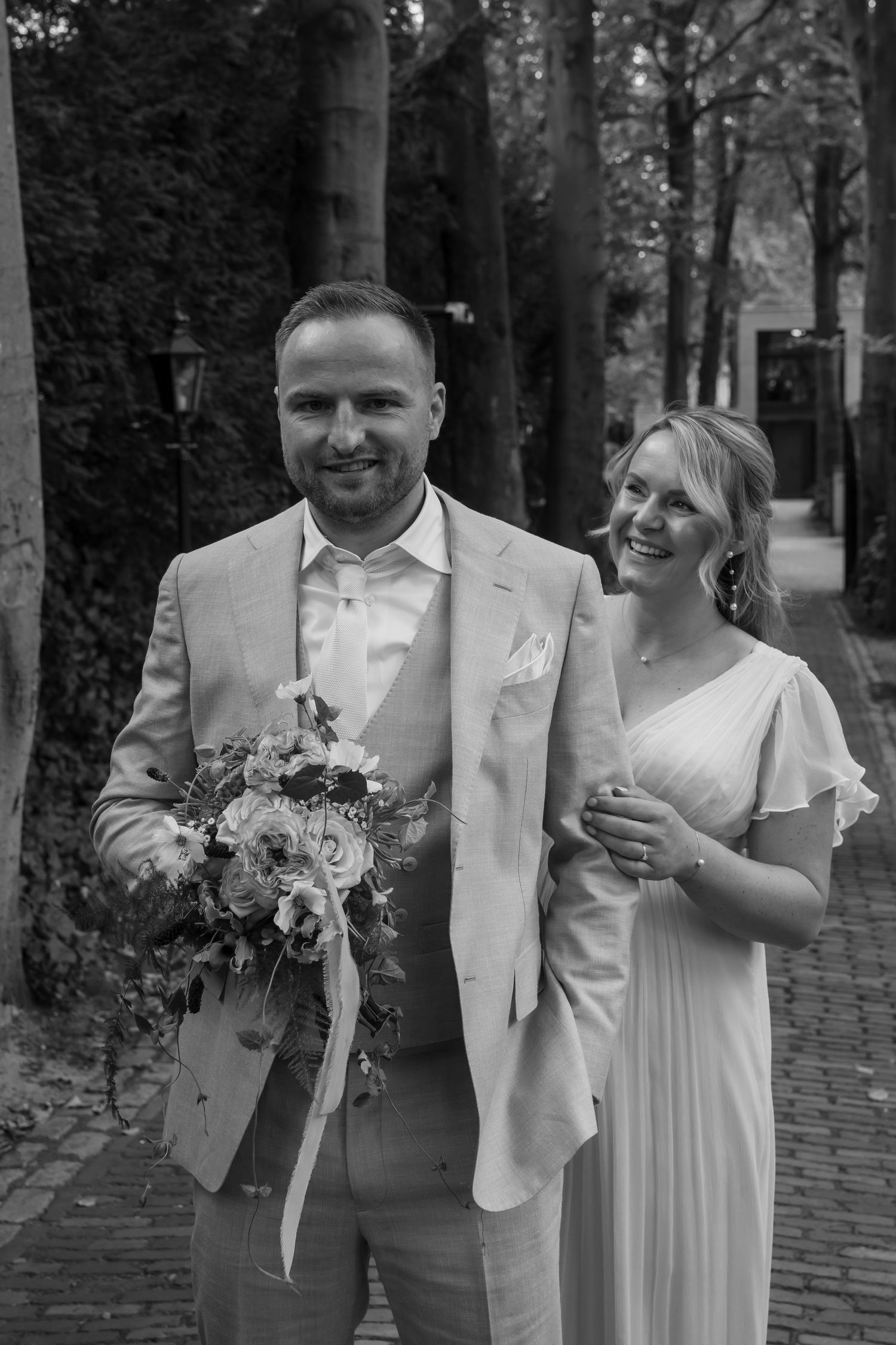 Wedding couple walking and laughing together in formal attire.