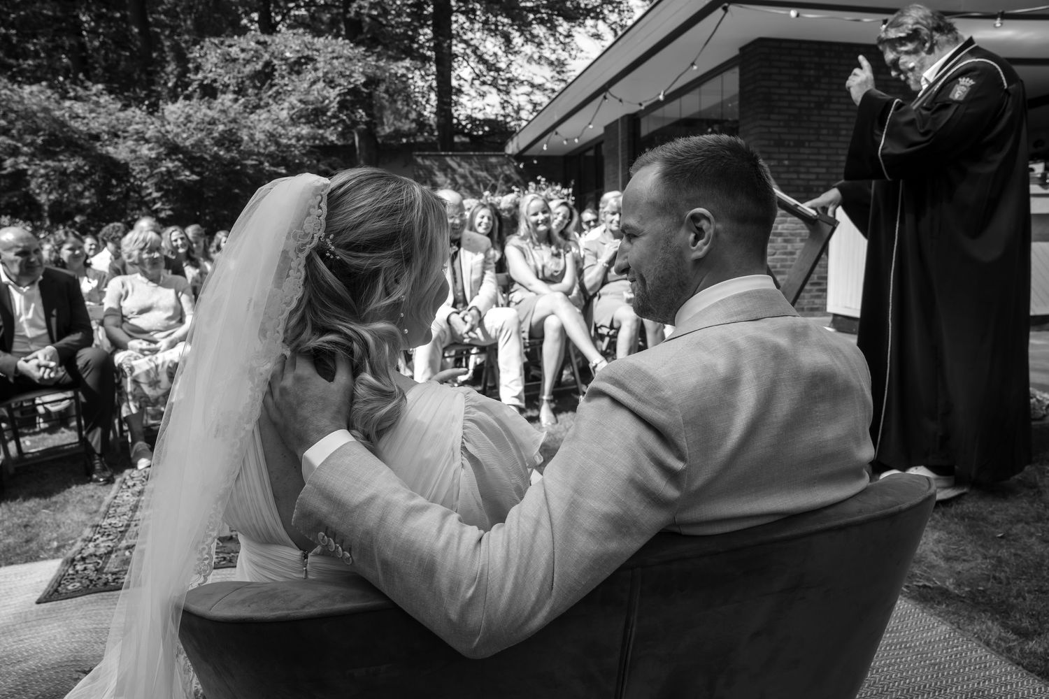 Black and white photo of couple celebrating during outdoor wedding ceremony.