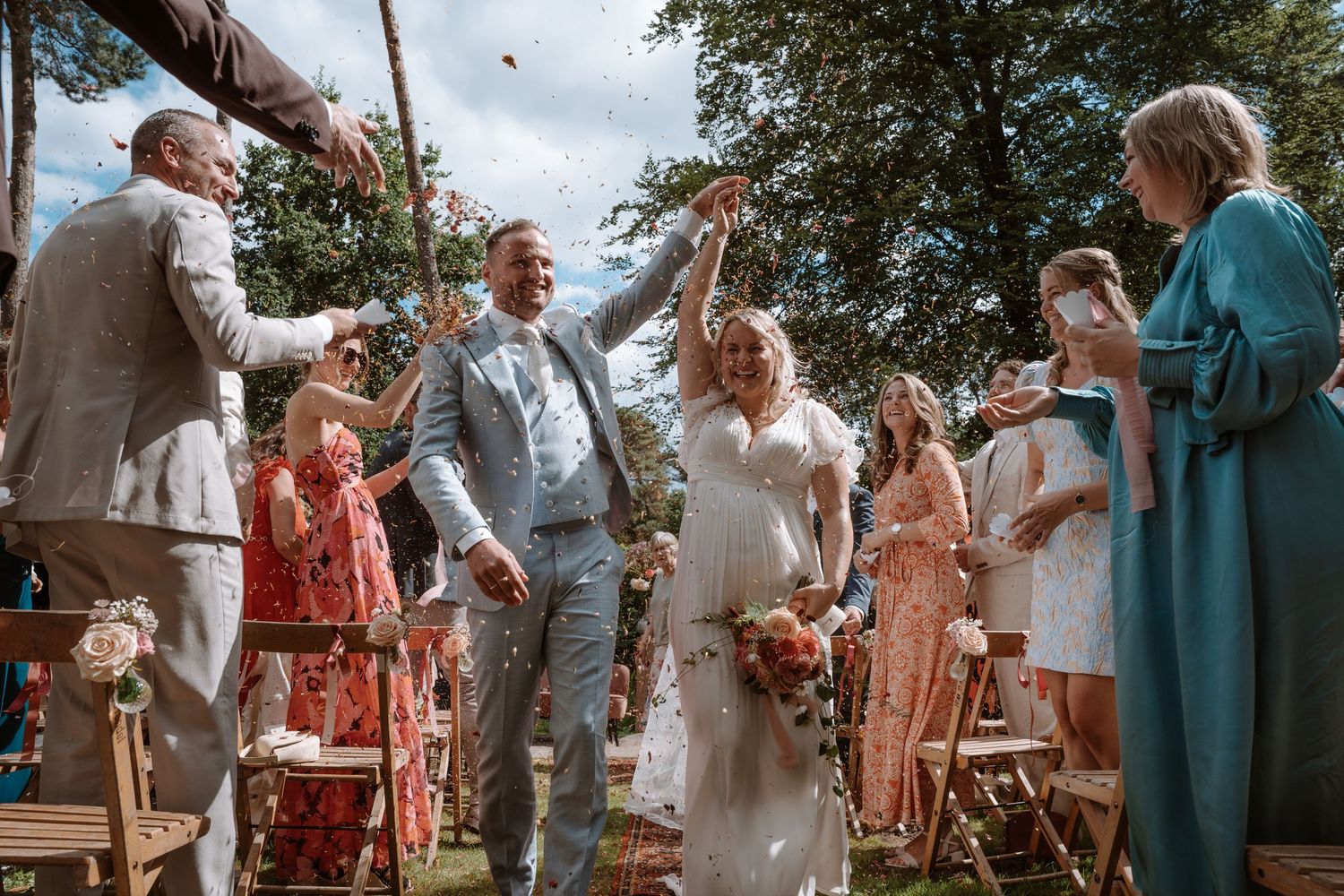 Joyful celebration moment during outdoor garden wedding ceremony.