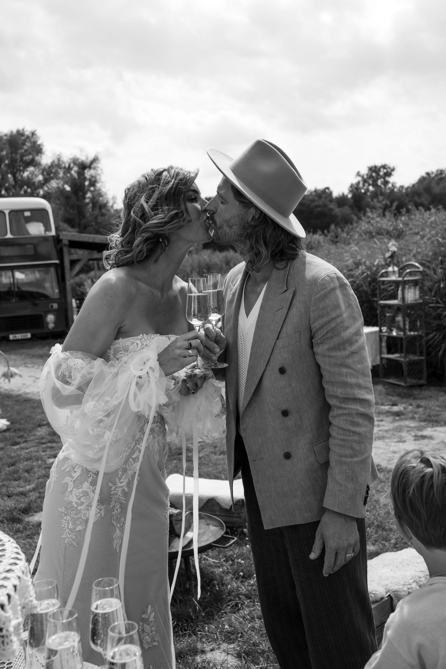 Black and white photo capturing an intimate wedding moment outdoors.
