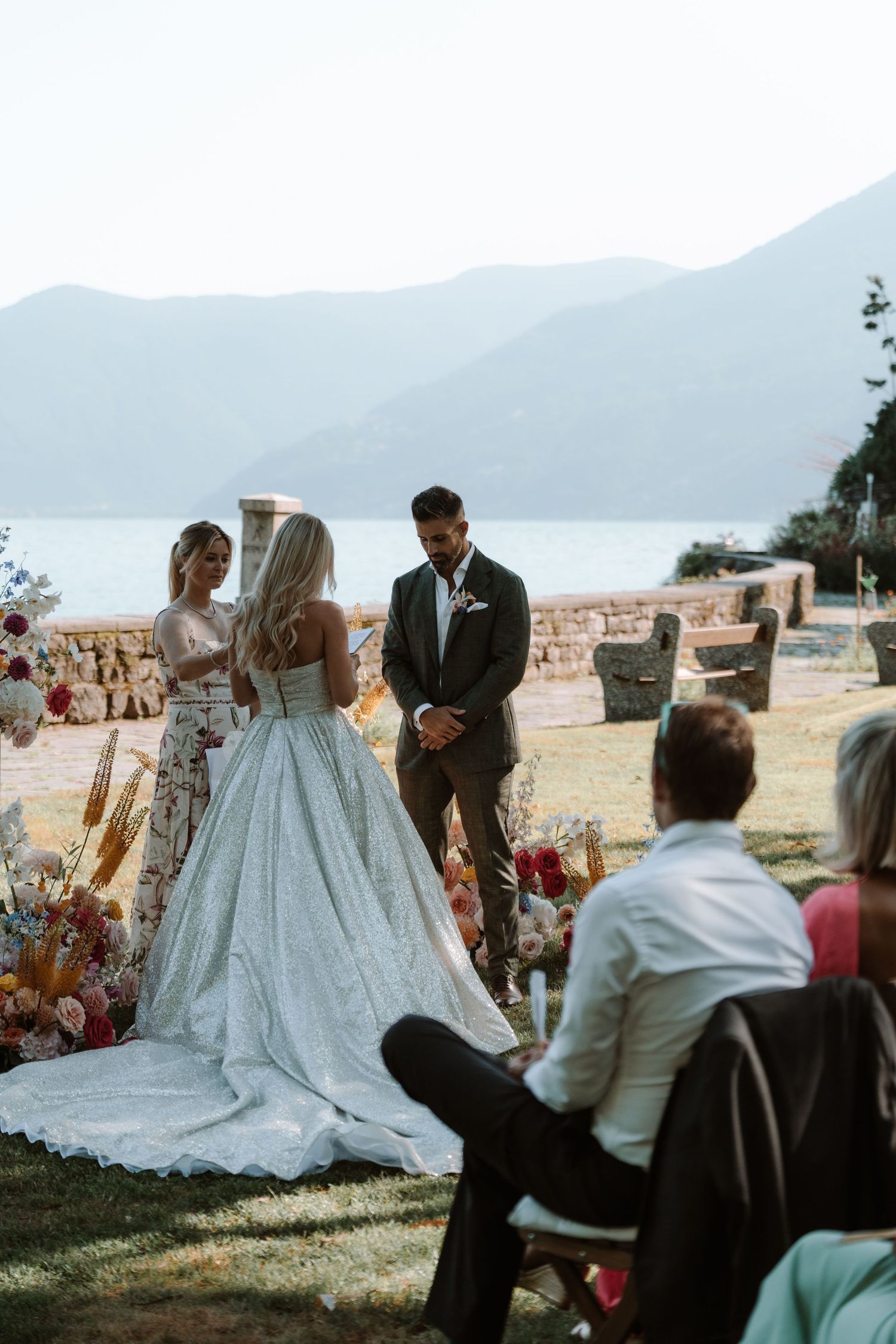 A romantic outdoor wedding ceremony with a scenic mountain backdrop and lake view.