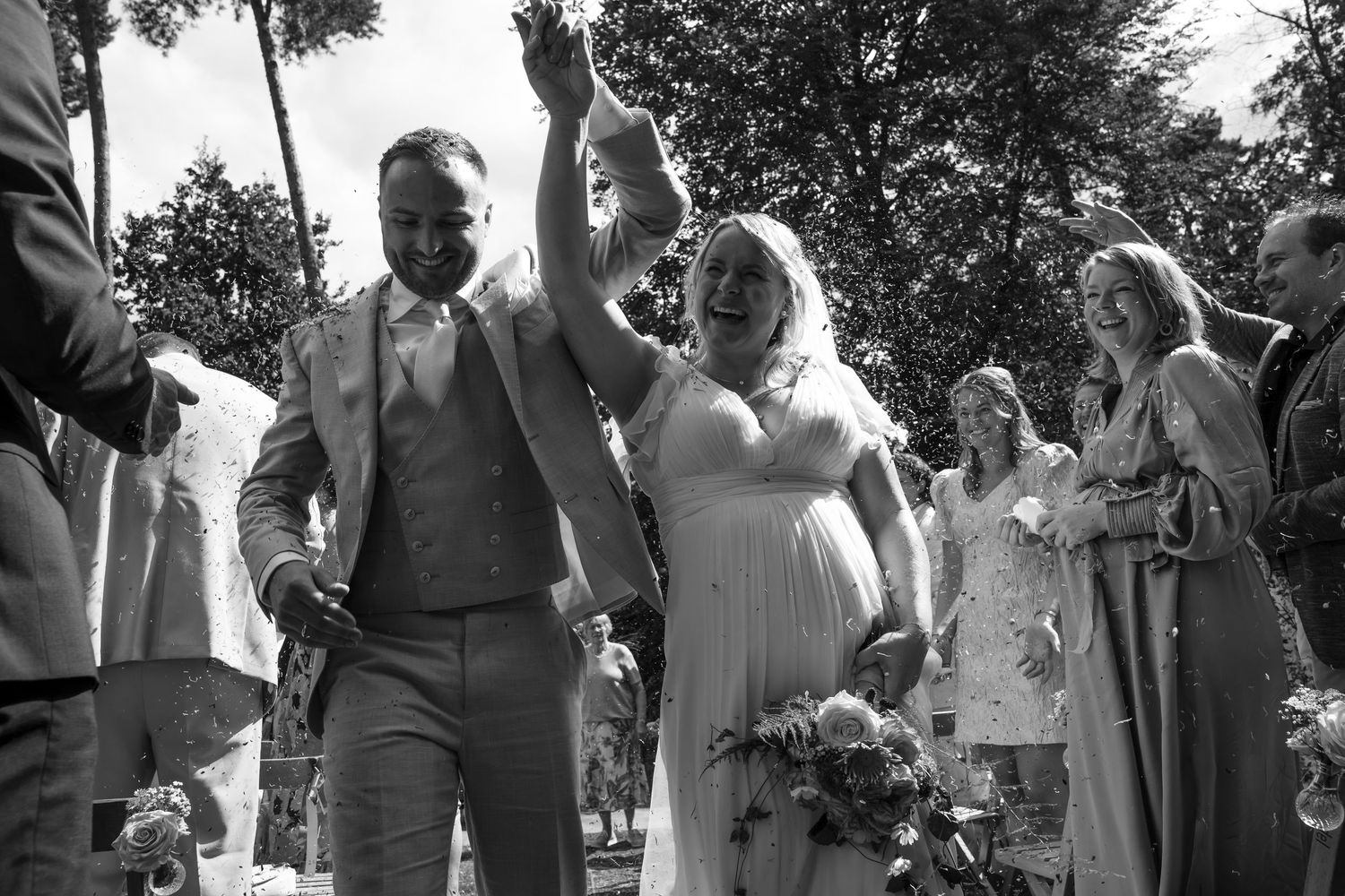 Black and white photo of wedding celebration in outdoor garden setting.