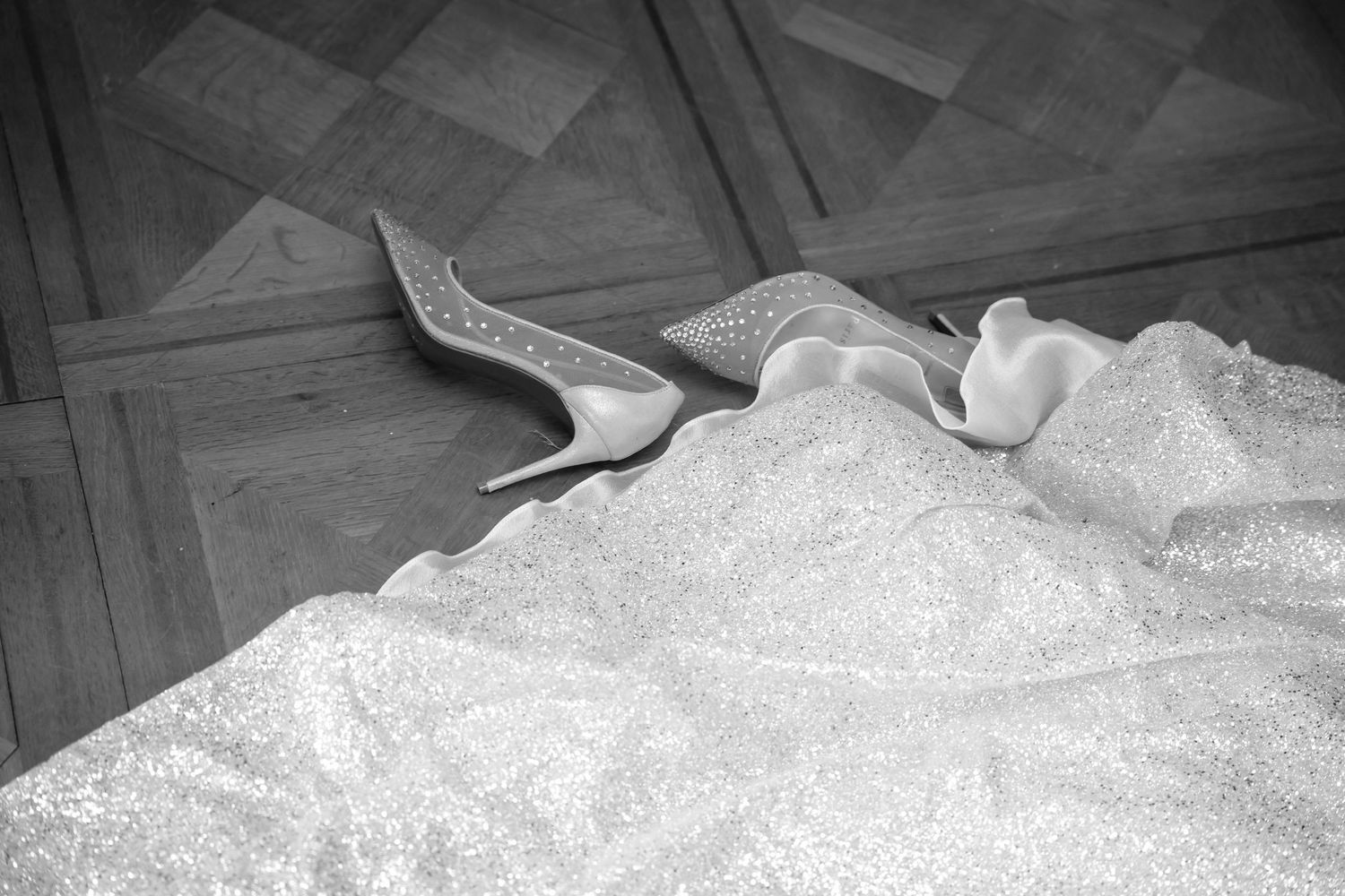 A black and white panoramic sequence showing a person lying down on a wooden floor.