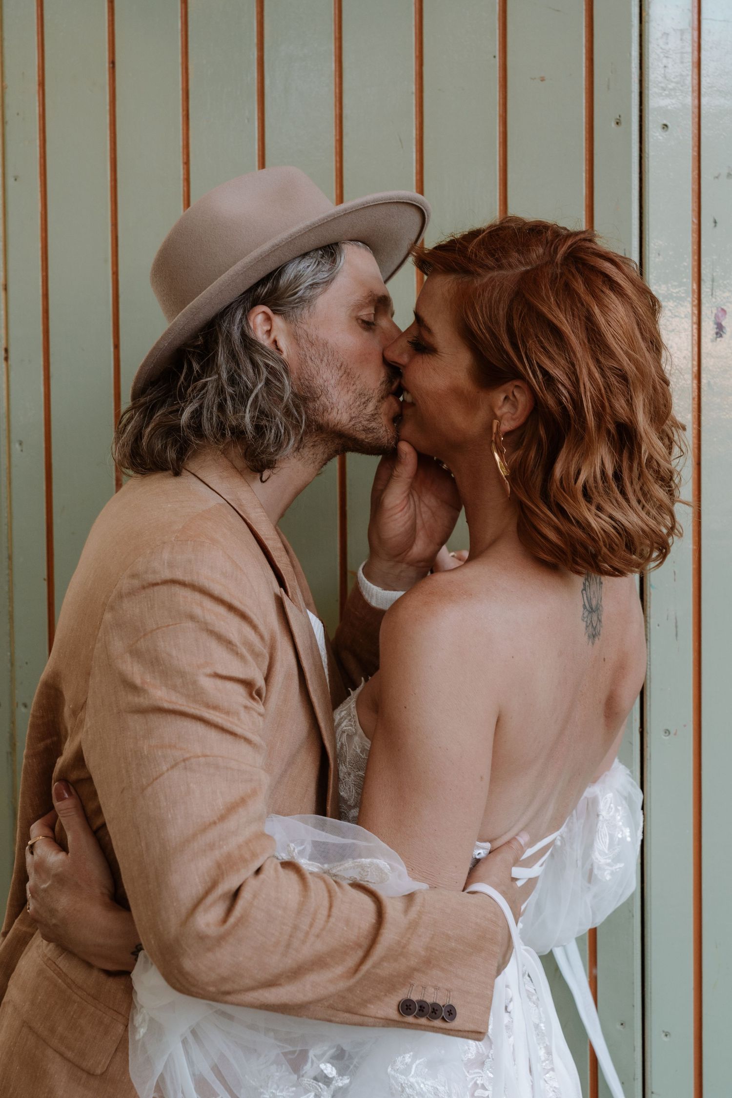 A romantic wedding moment captured in a series of intimate photos against a striped wall.