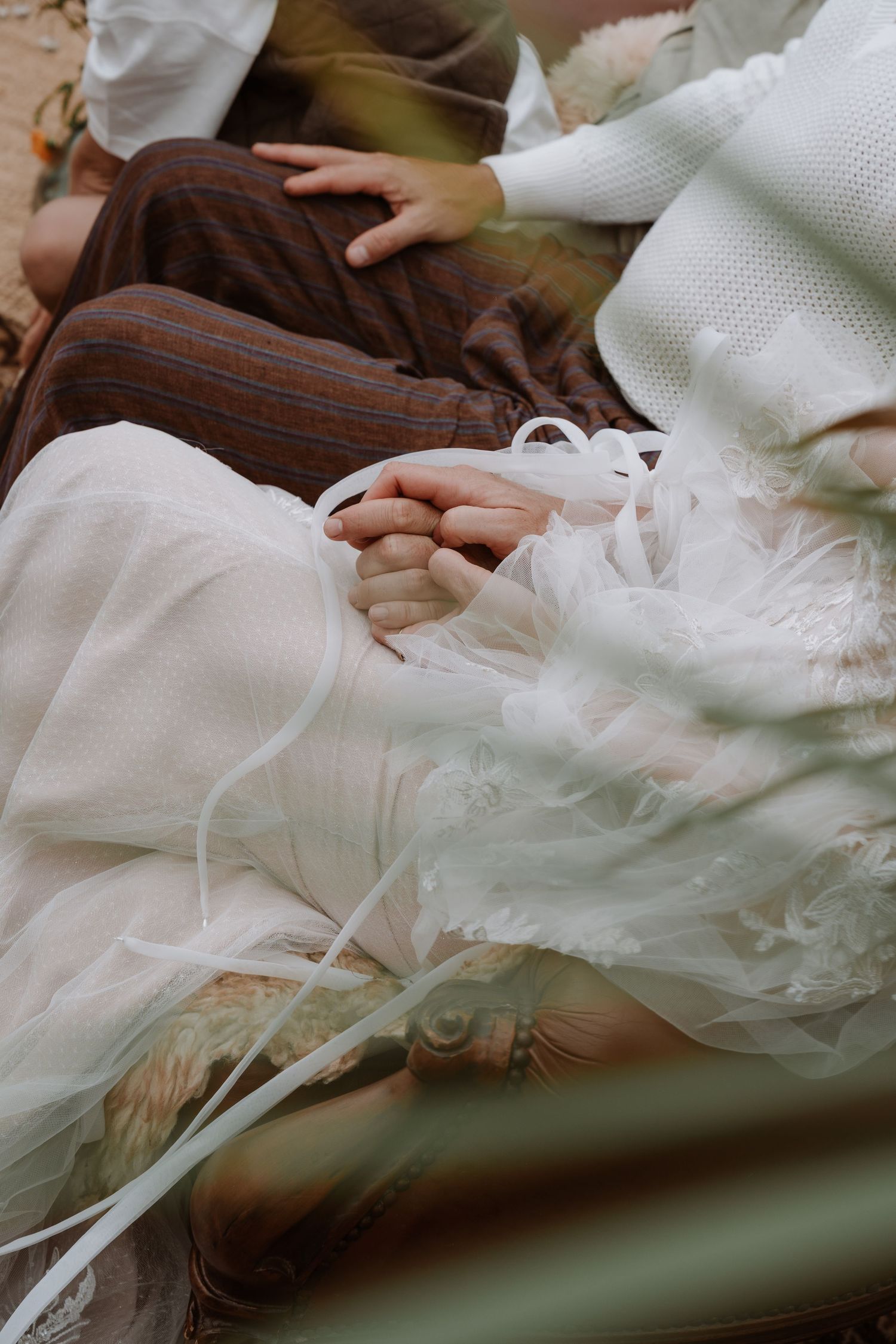 Close-up detail of white wedding dress fabric with intricate lace patterns.