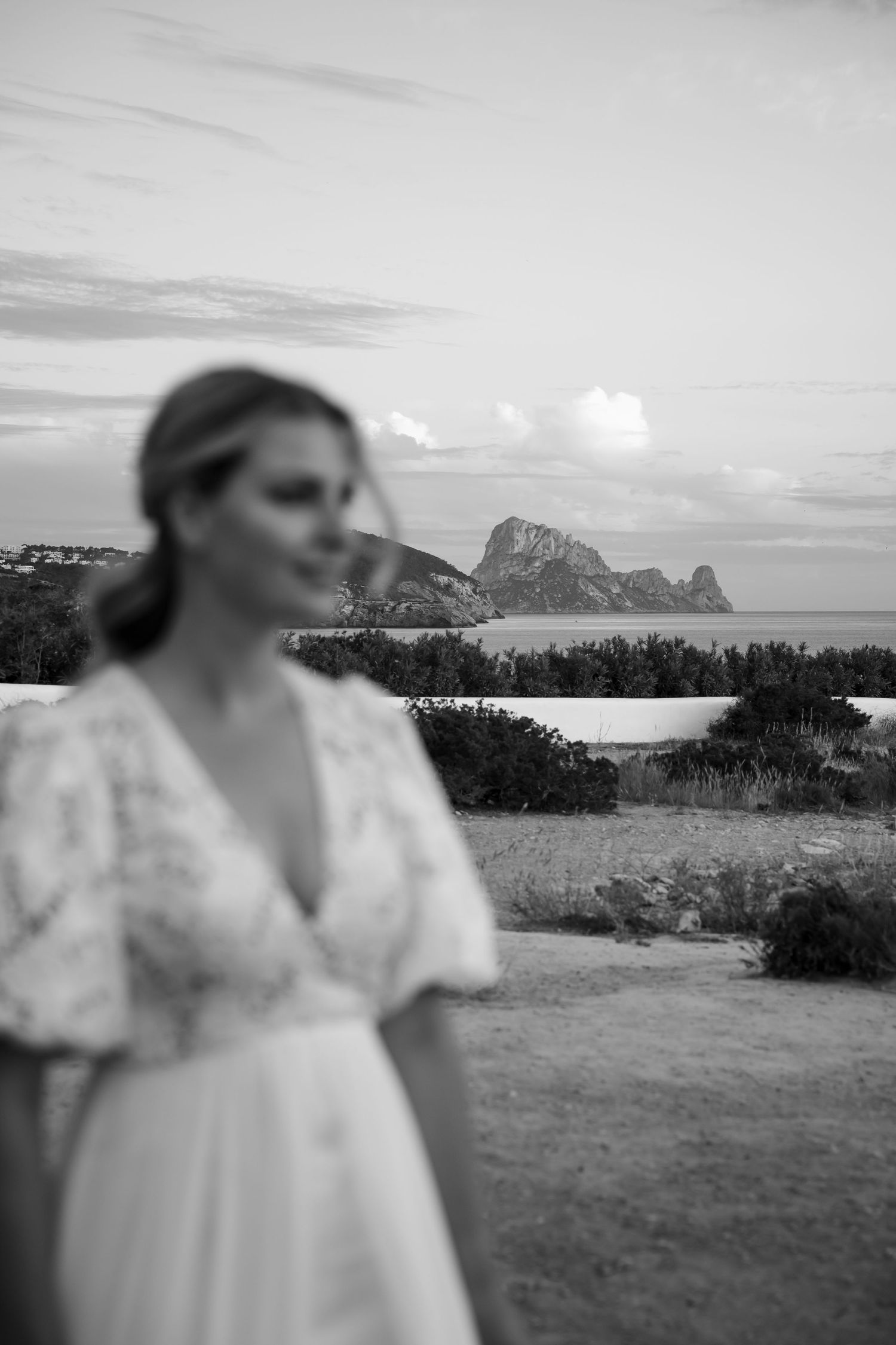 Dreamy black and white portrait with coastal mountains in background.