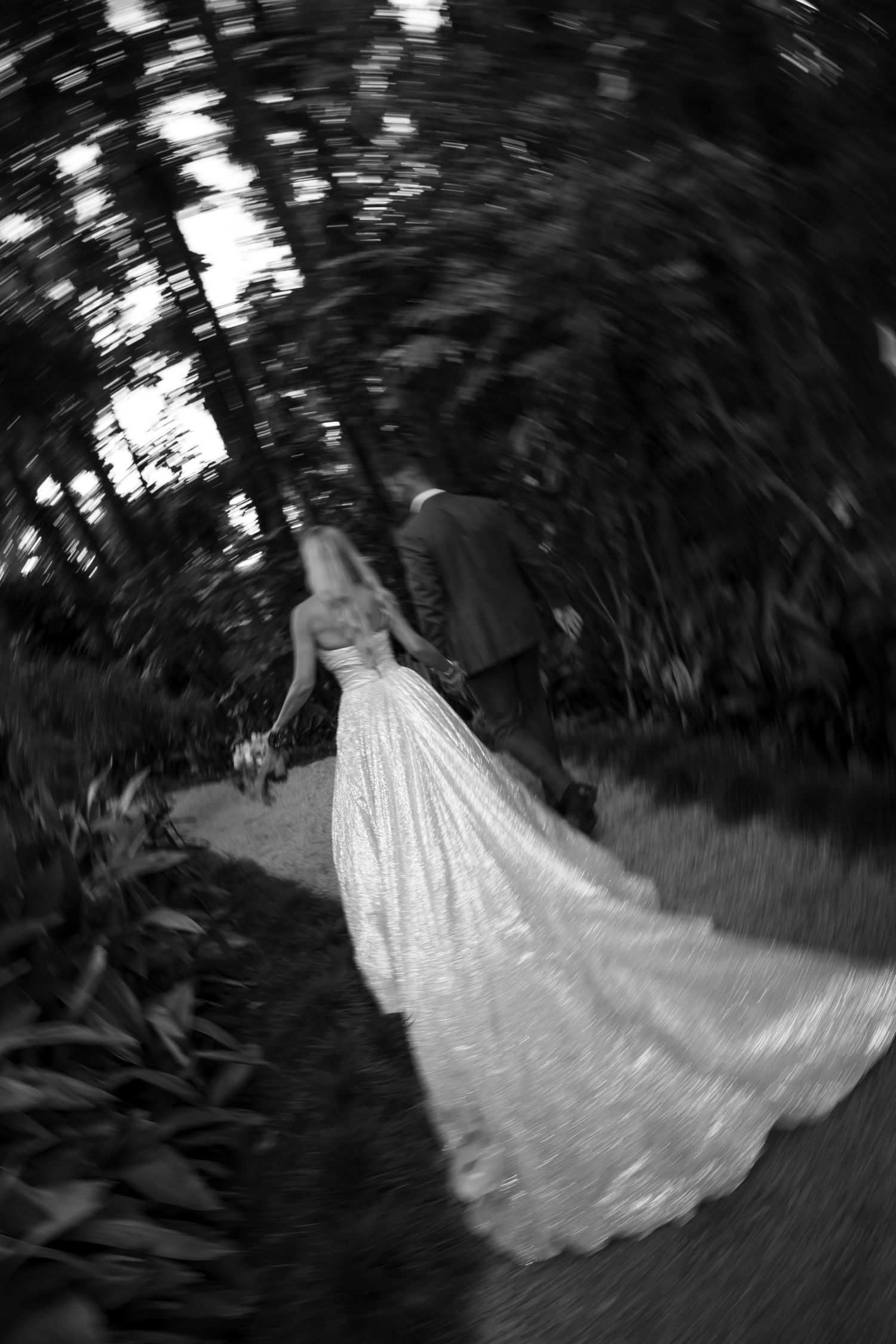 A sequence of black and white photos showing a bride in a flowing white wedding dress spinning in a garden setting.