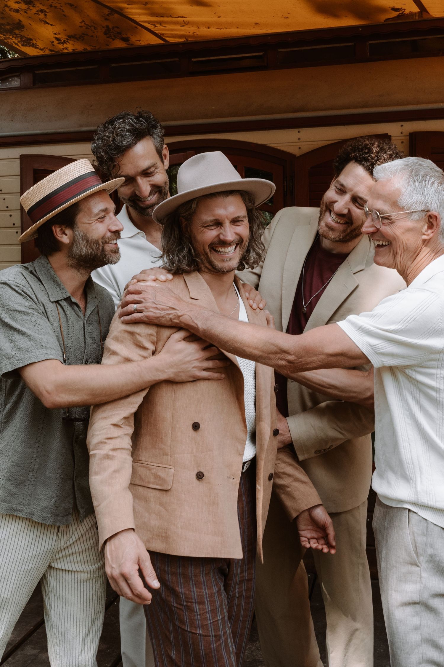 Group of people in vintage attire sharing emotional embraces at a celebration.
