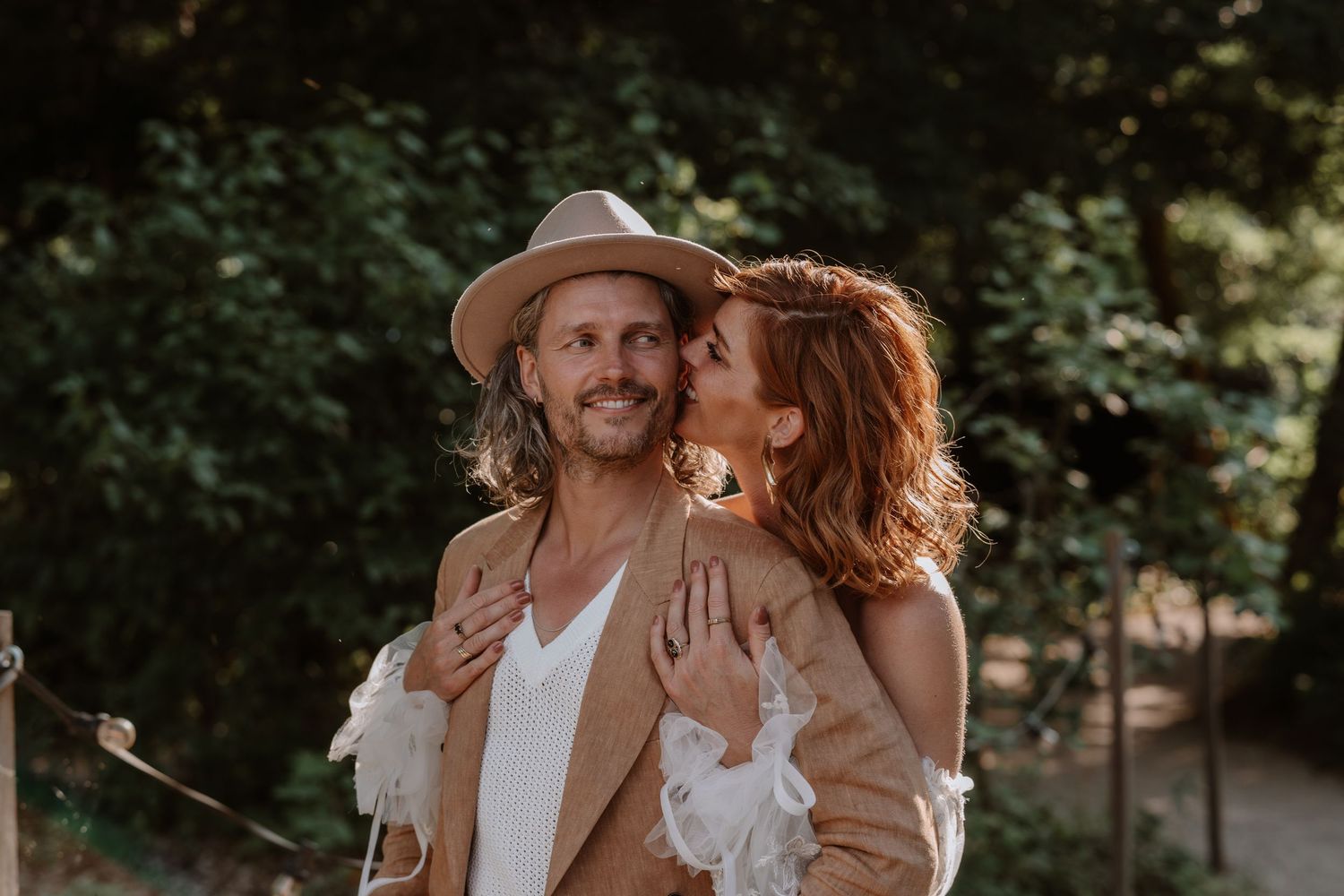 Couple in casual attire enjoying a romantic moment outdoors.